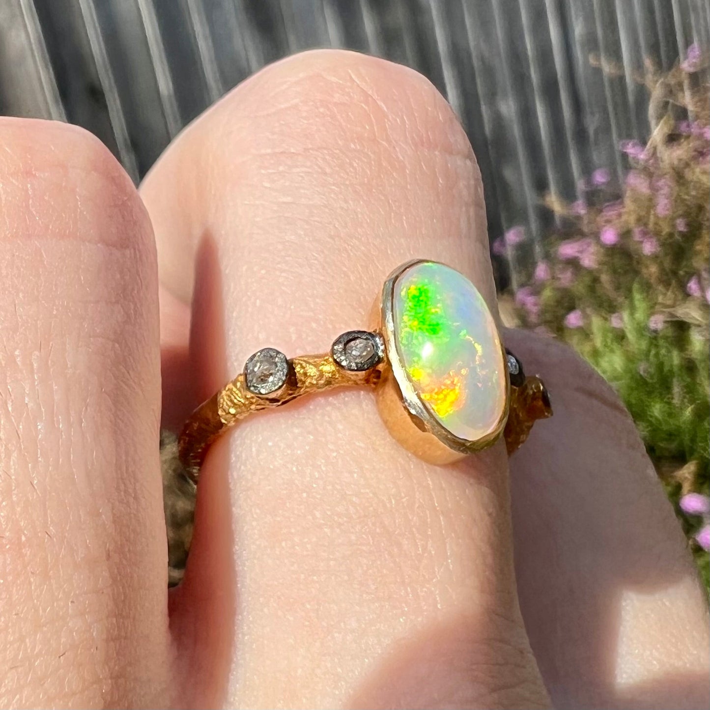 A yellow gold plated sterling silver ring mounted with an Ethiopian fire opal and rose cut diamond accents.