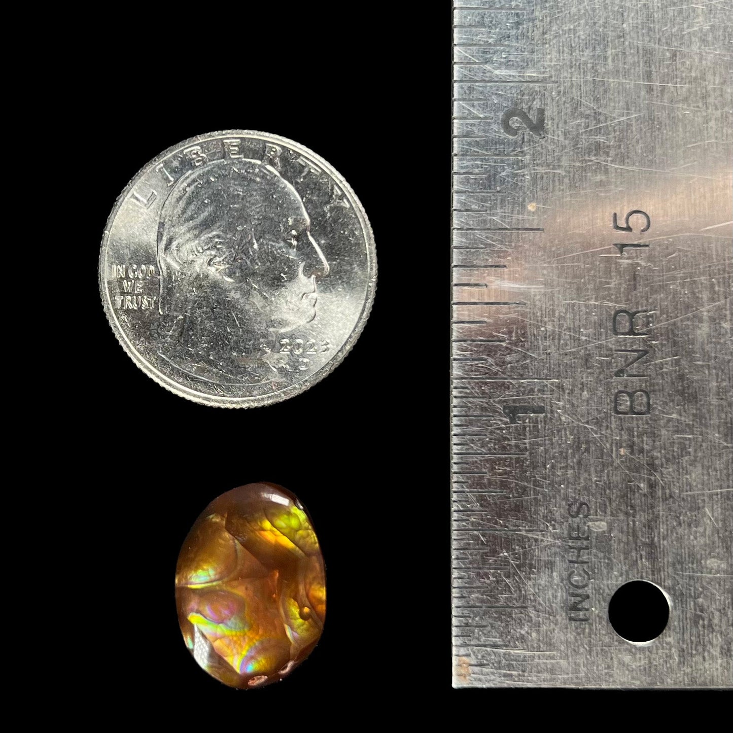 A loose, oval cabochon cut Mexican fire agate stone with pink, orange, and purple banding.