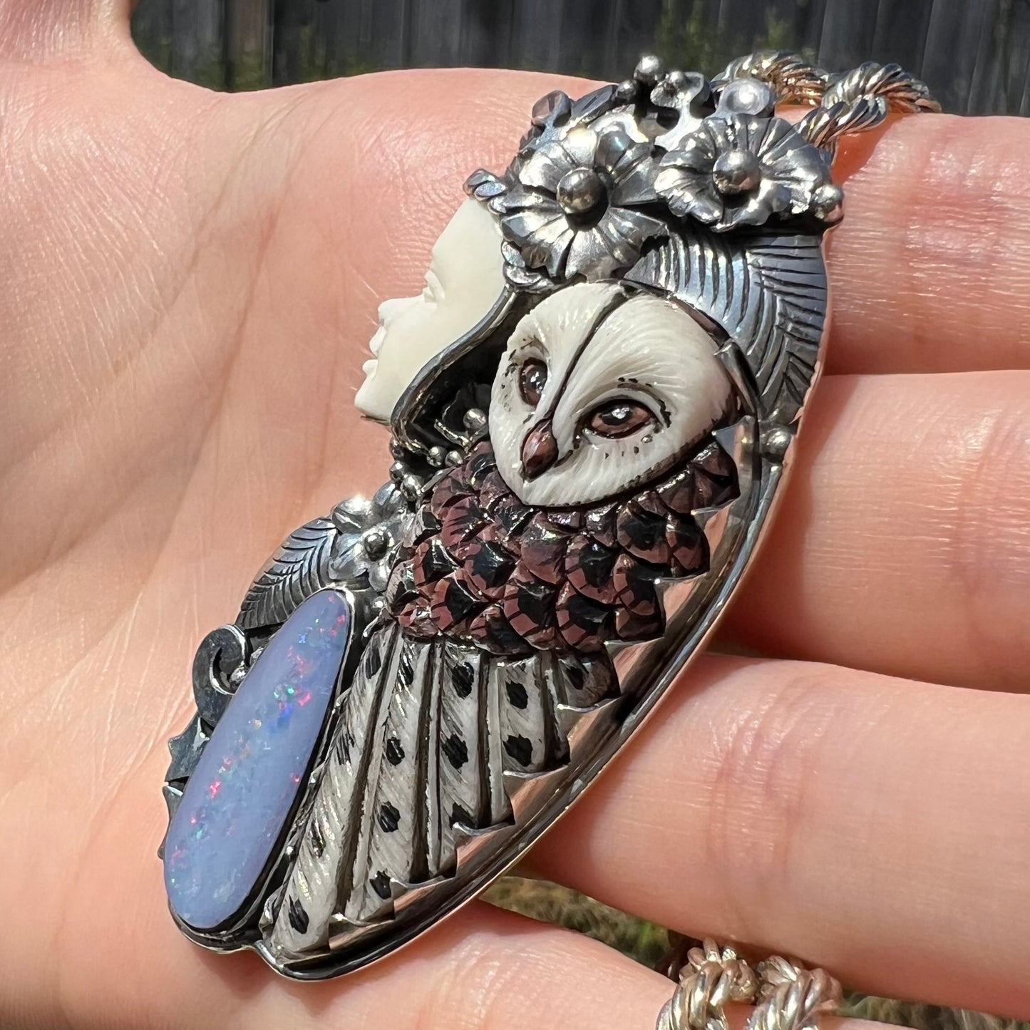 A woman and owl necklace with a nature-inspired motif, made from sterling silver, bone, and an opal doublet.