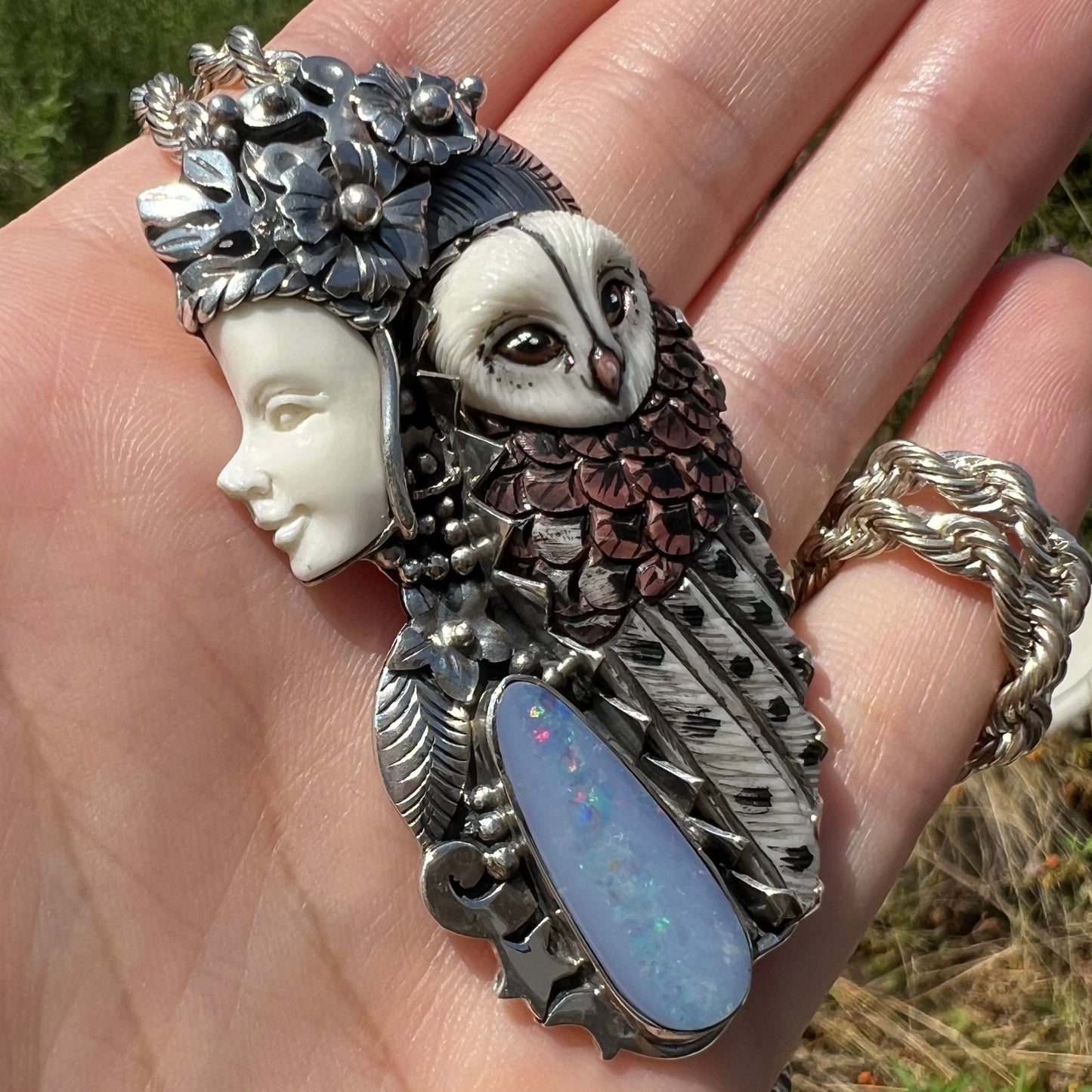 A woman and owl necklace with a nature-inspired motif, made from sterling silver, bone, and an opal doublet.