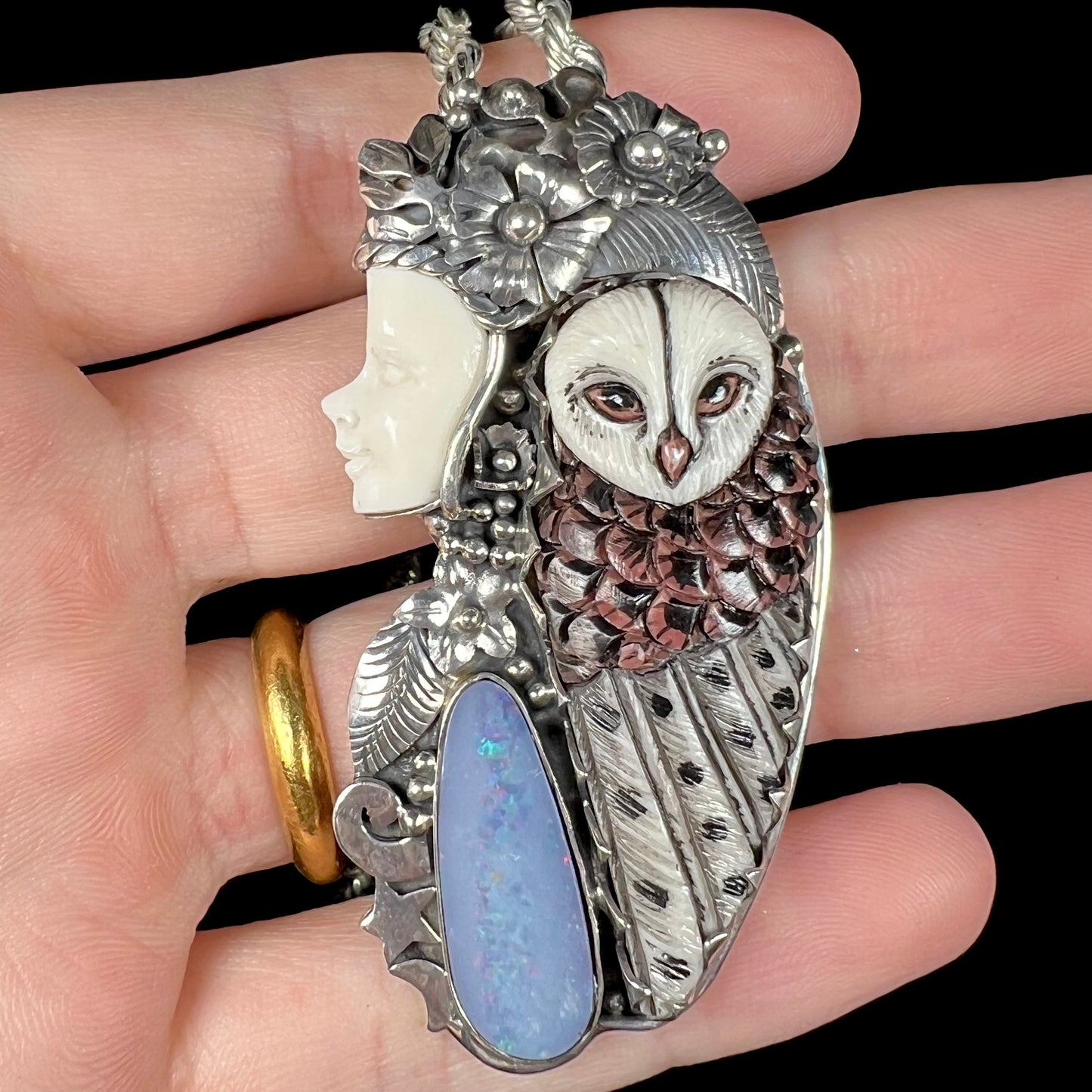 A woman and owl necklace with a nature-inspired motif, made from sterling silver, bone, and an opal doublet.