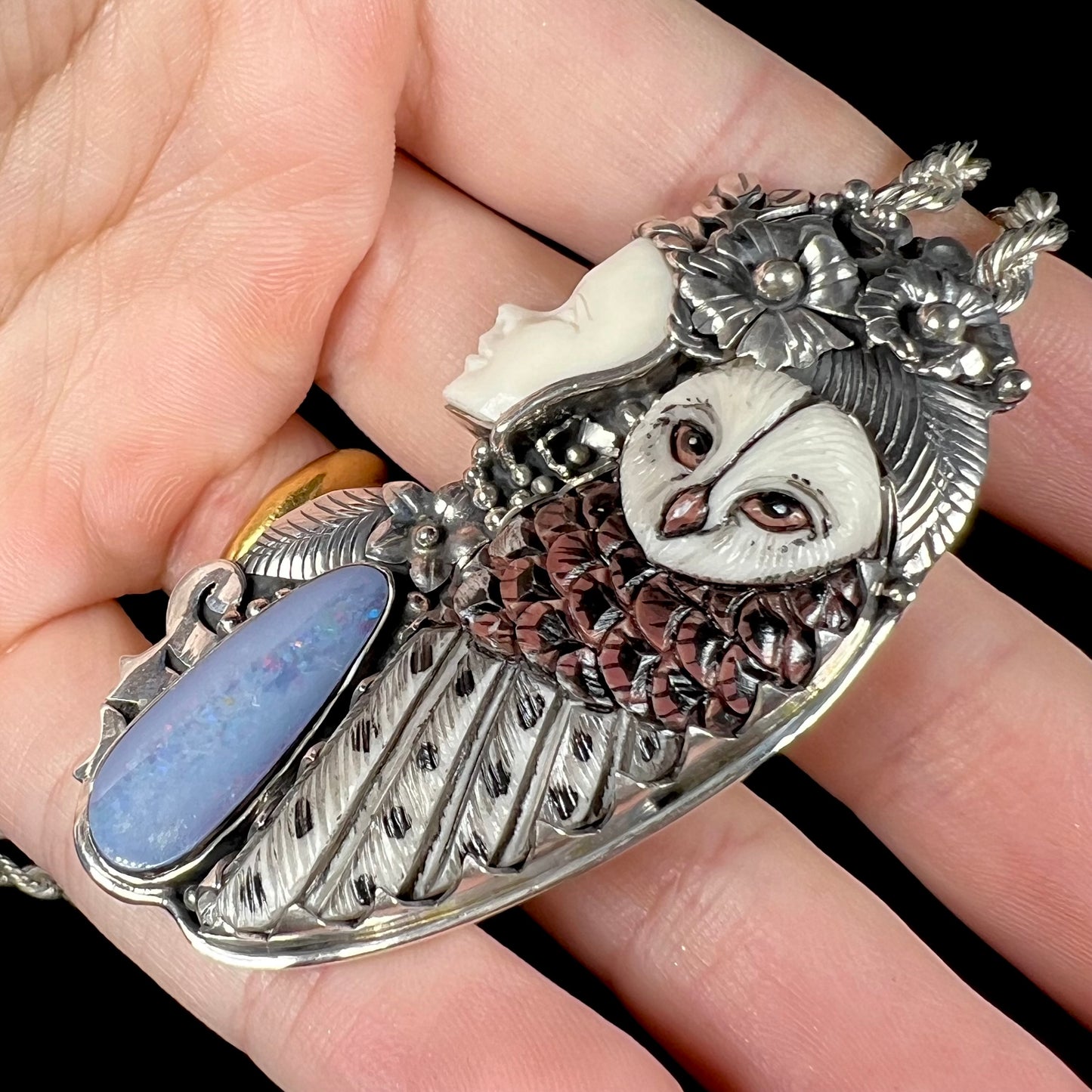 A woman and owl necklace with a nature-inspired motif, made from sterling silver, bone, and an opal doublet.