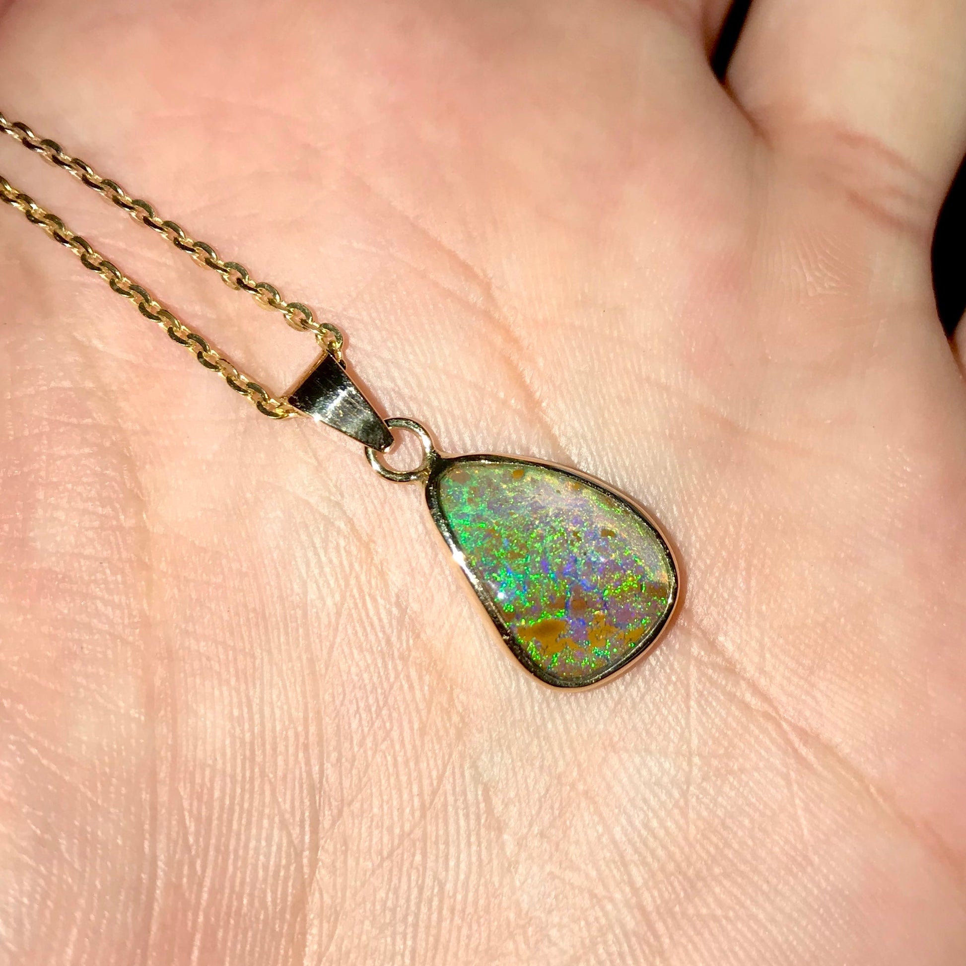 Natural green and salmon pink Australian boulder opal set in a 14 karat yellow gold bezel pendant on a gold plated sterling silver cable link chain.