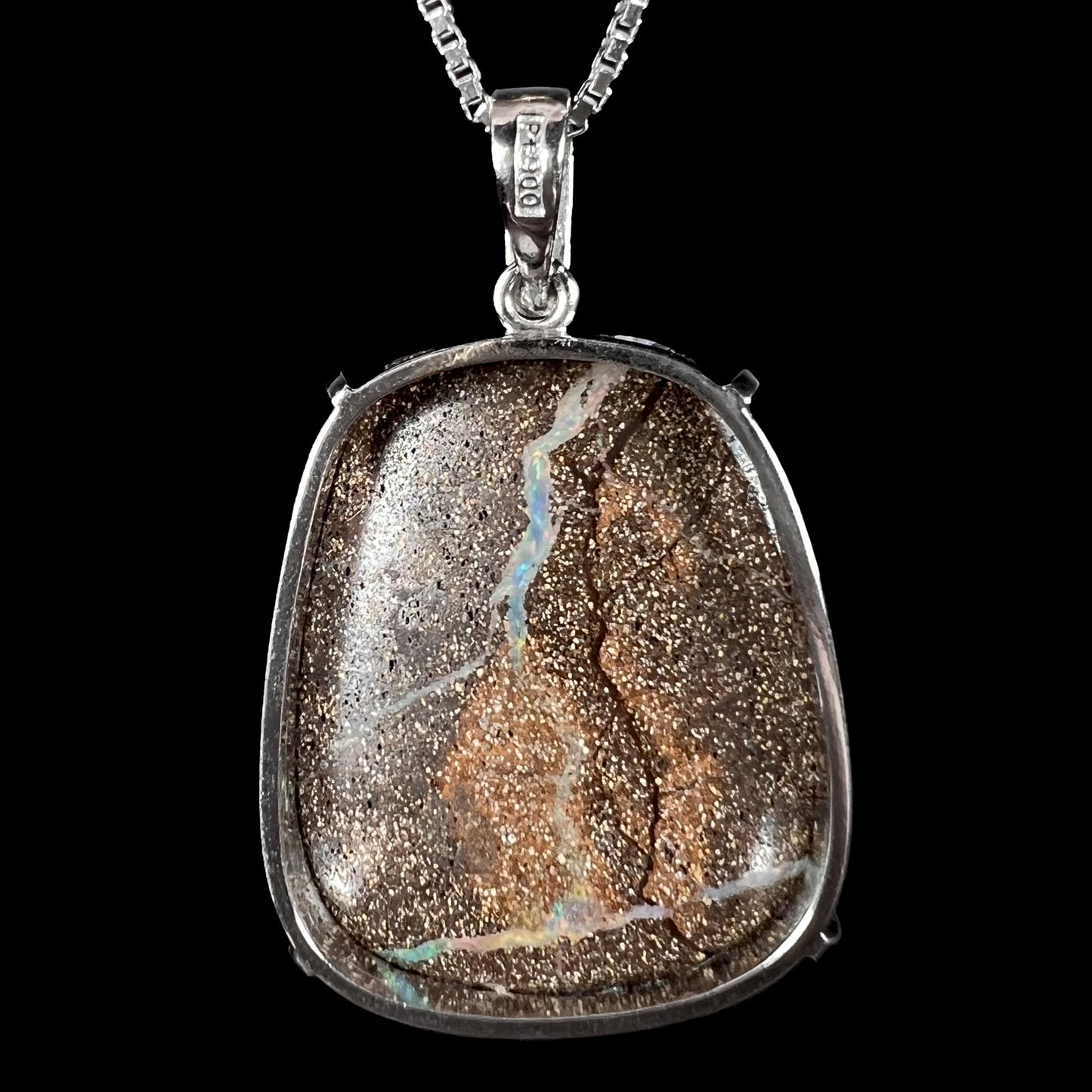 Back of a platinum boulder opal pendant showing the natural ironstone matrix and ‘Pt900’ hallmark stamp on the bail.