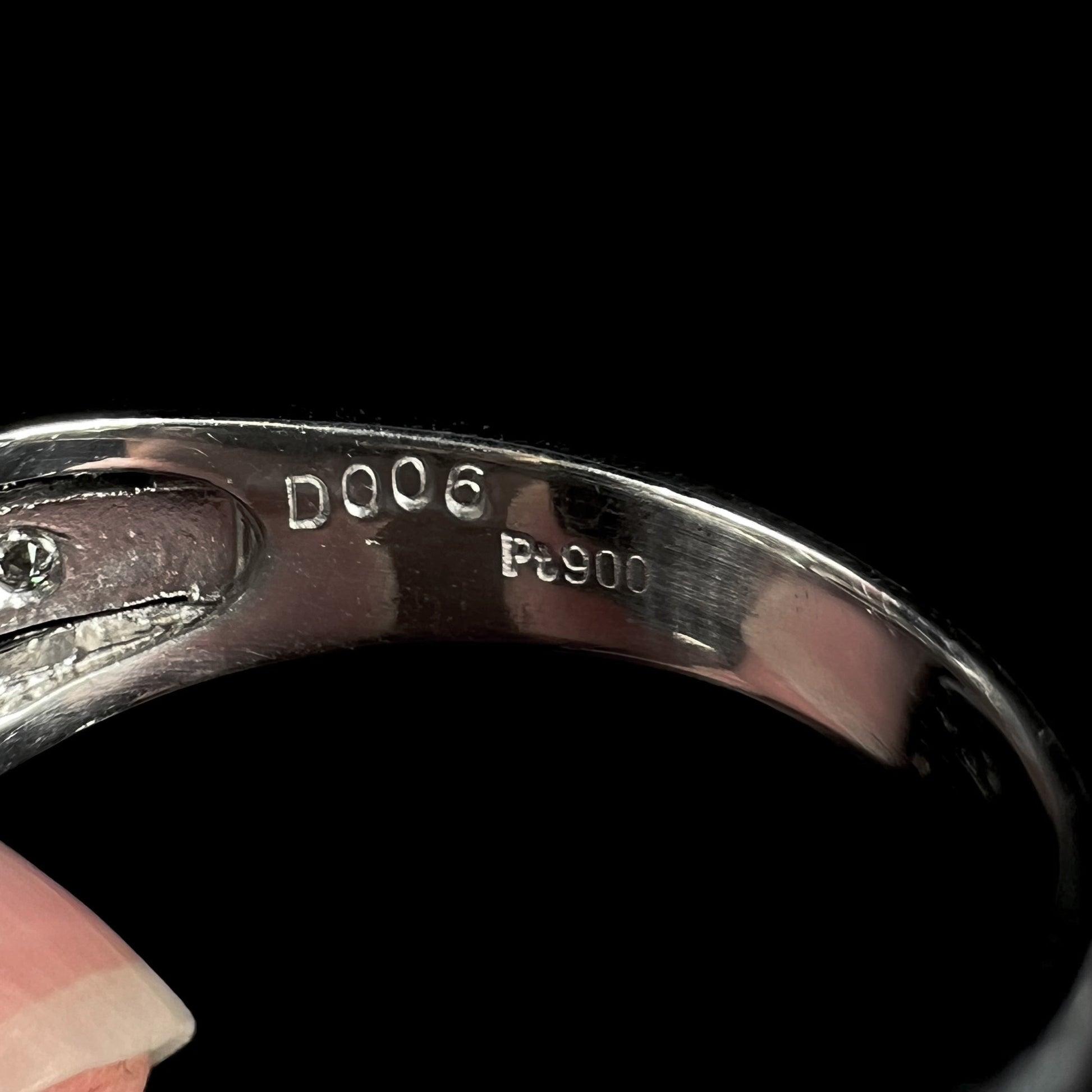 Inside of a platinum ring's shank showing the hallmarks, "D006" and "Pt900".