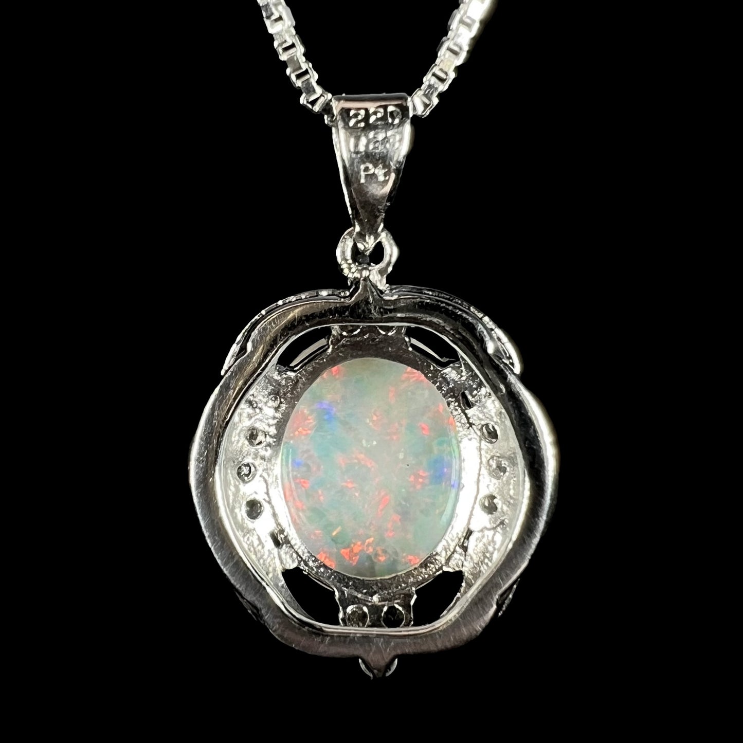 Back view of a platinum opal necklace against a black background. The bail is stamped "220", "023", and "Pt".