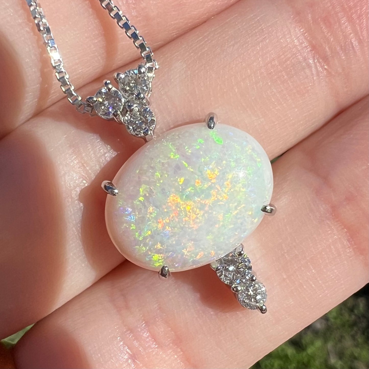 A close-up macro of the best angle in sunlight, showing an orange flash in the center of the opal surrounded by green hues.