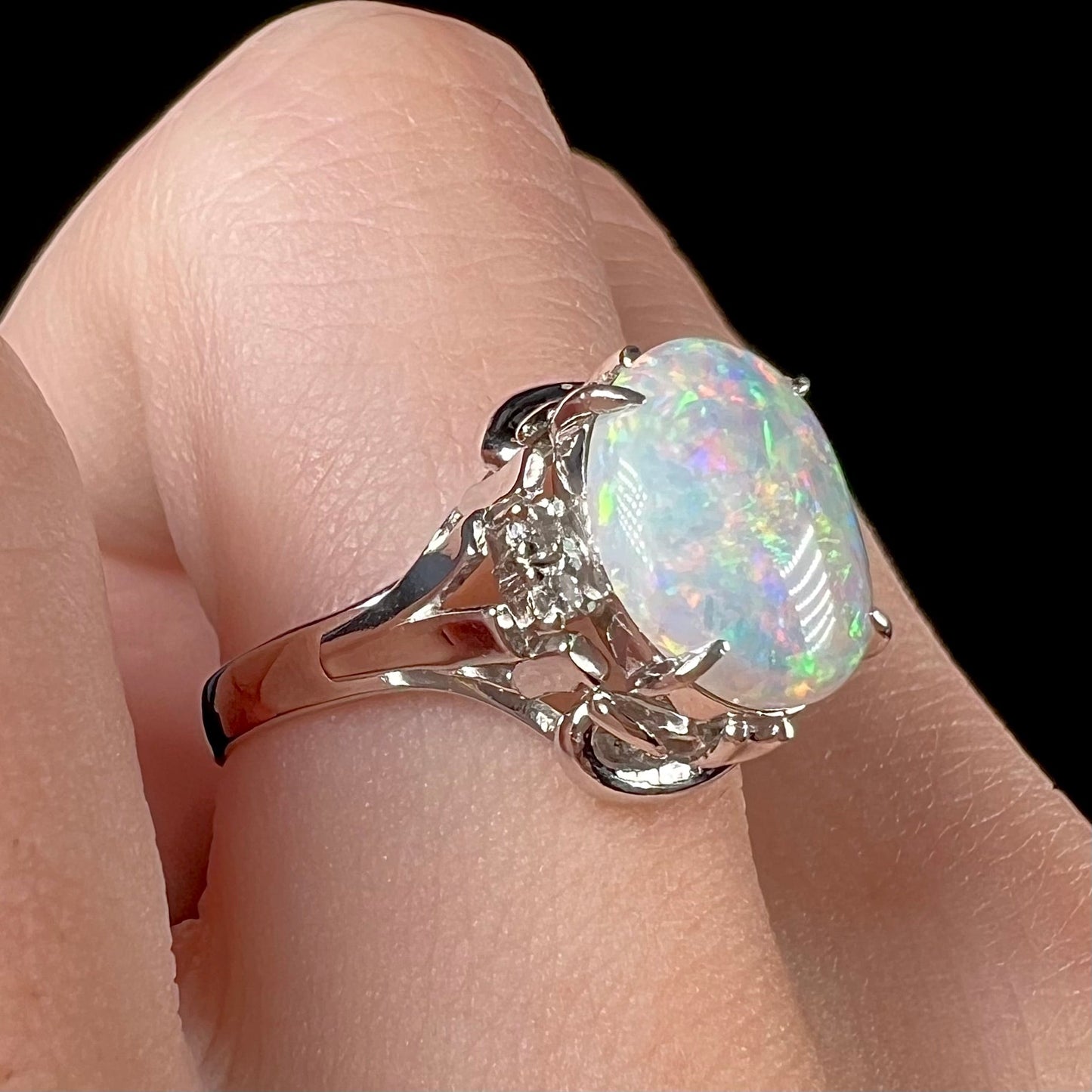A platinum and diamond ring prong-set with an Australian opal. The opal has pink color play.
