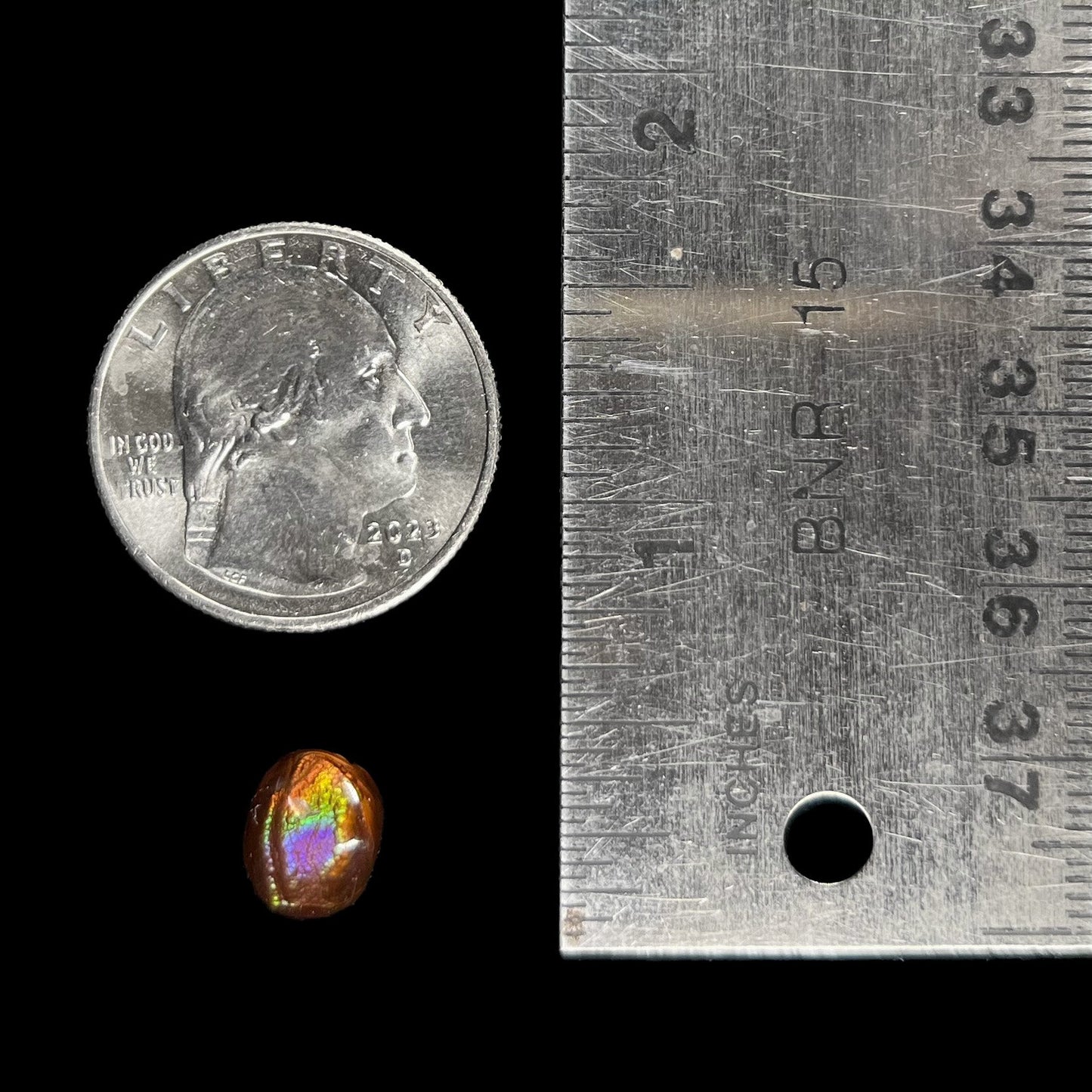 A loose, oval cabochon cut fire agate stone from Mexico. The stone has an iridescent purple and teal blue eye of color.