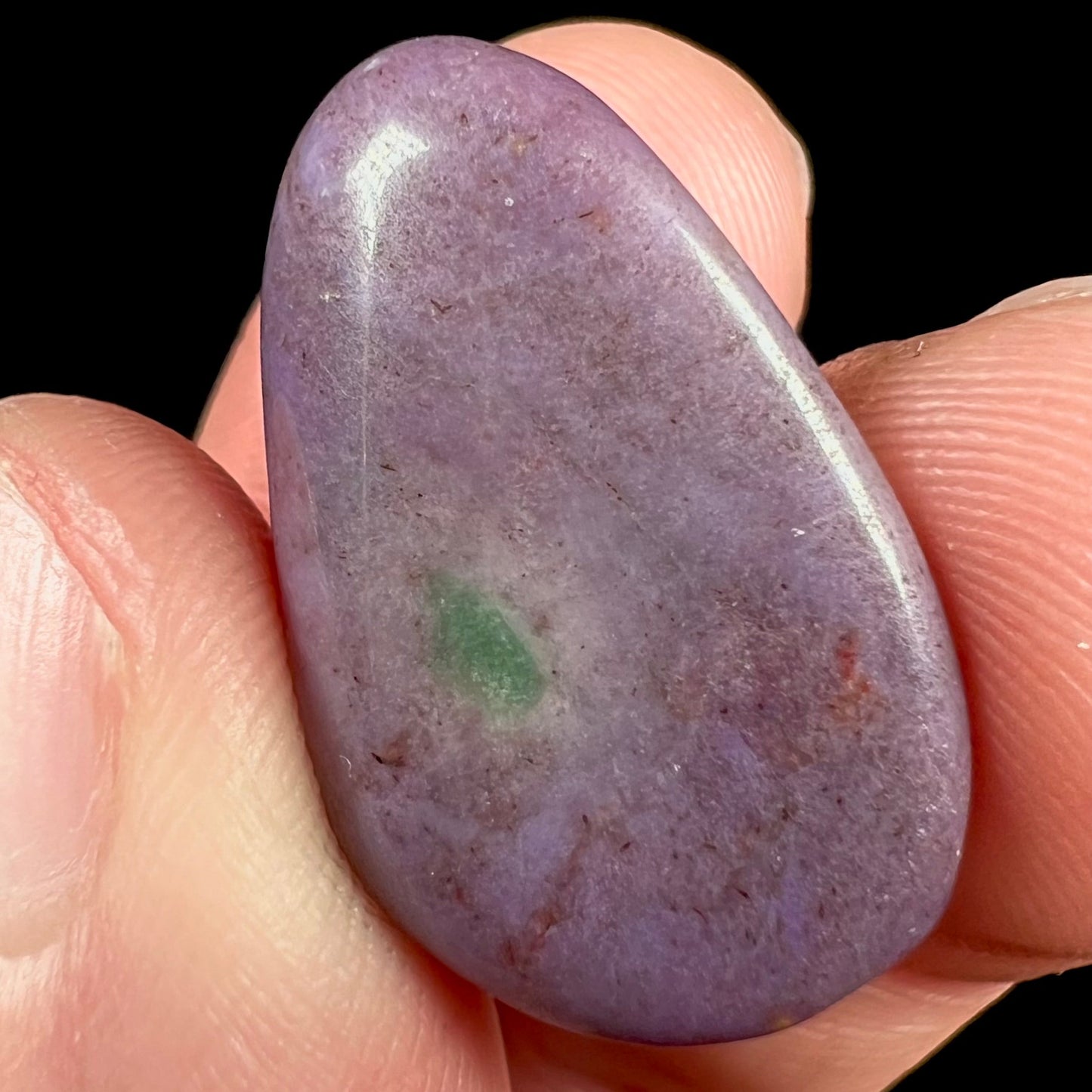 A tumbled purple turkiyenite jade stone from Borsa, Turkey. The stone has a green jadeite inclusion.