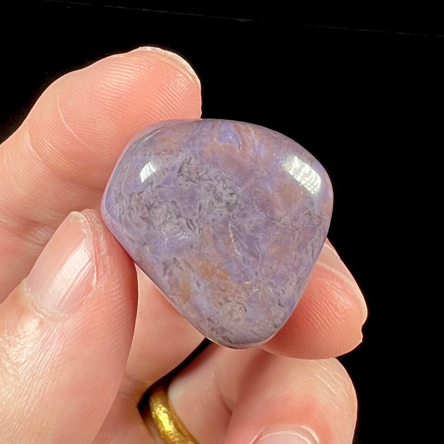 A tumbled turkiyenite stone, commonly referred to as "Turkish purple jade."