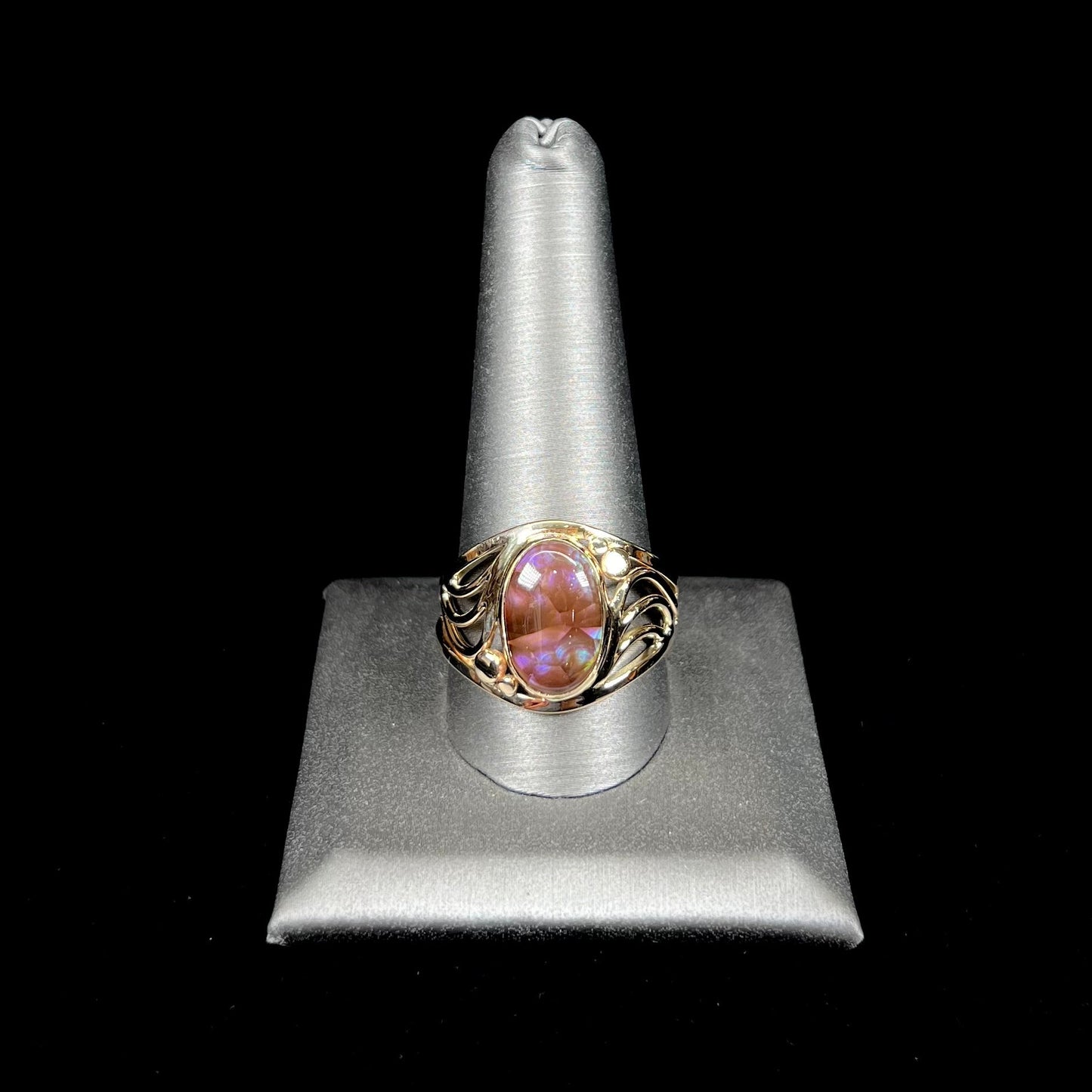 A men's yellow gold fire agate ring. The fire agate is blue and purple with light scratches.