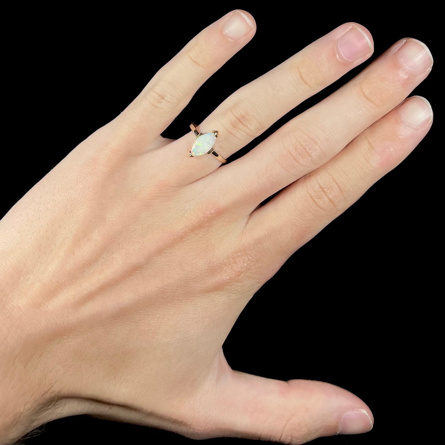 A marquise cut natural opal solitaire ring in yellow gold.