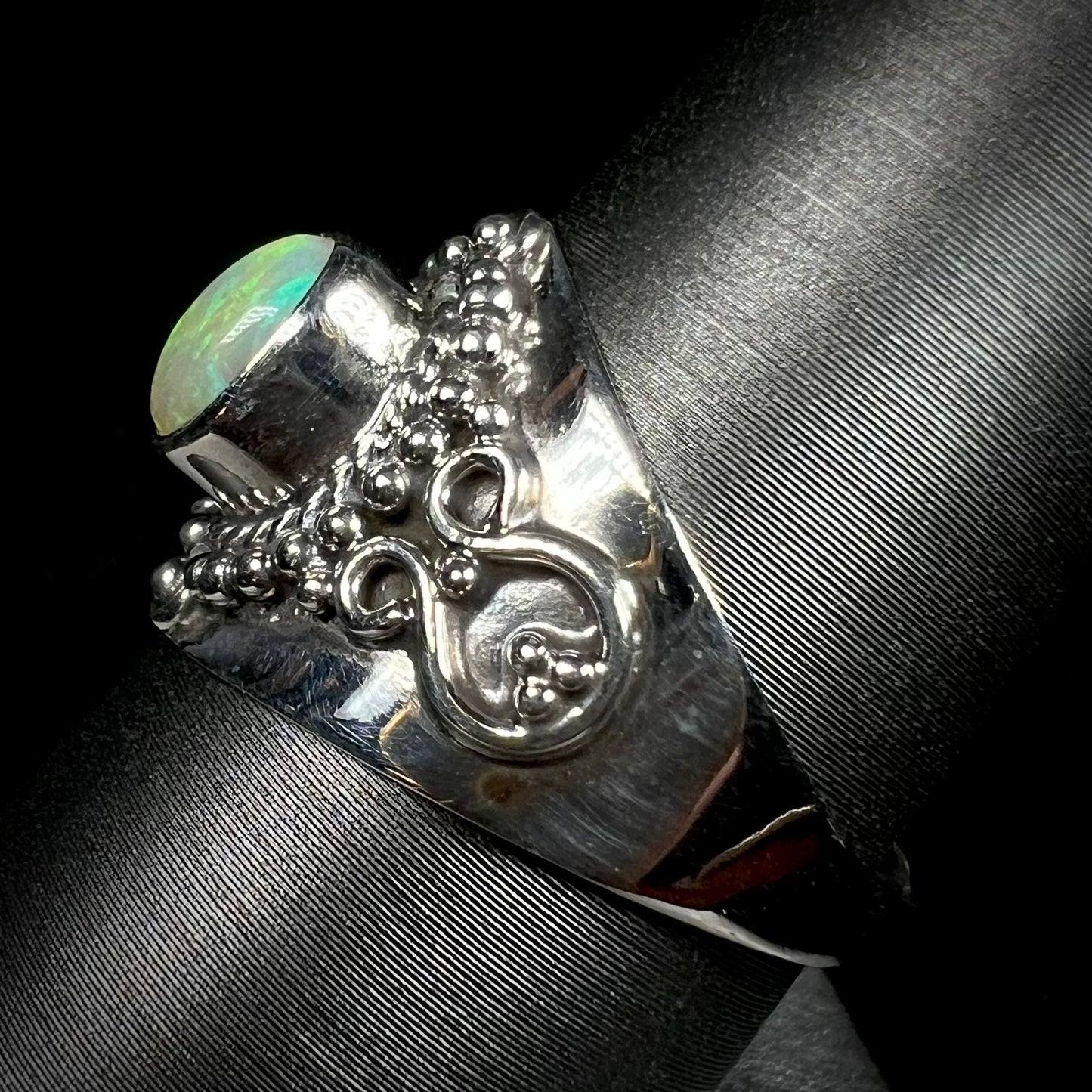 A silver boho opal ring shown from the side at a 90 degree angle.