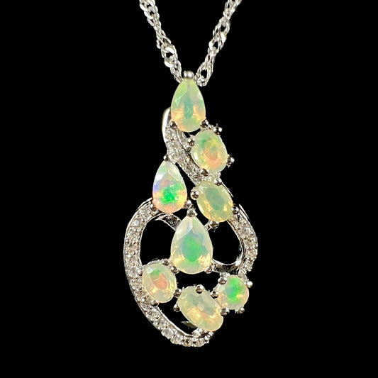 The front of a sterling silver Ethipoian opal and cz necklace with an elegant design, shown on a black background.