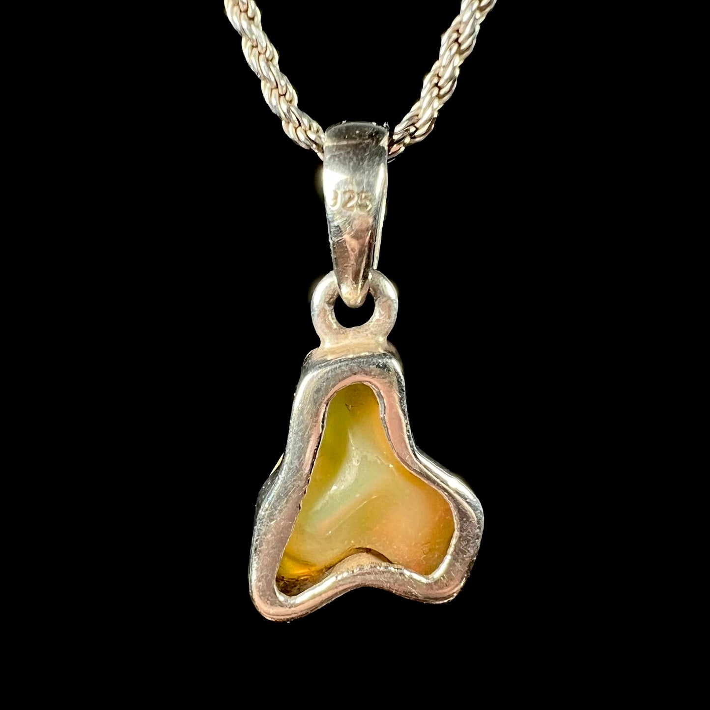 A freeform shaped Mexican fire opal necklace on a sterling silver rope chain.