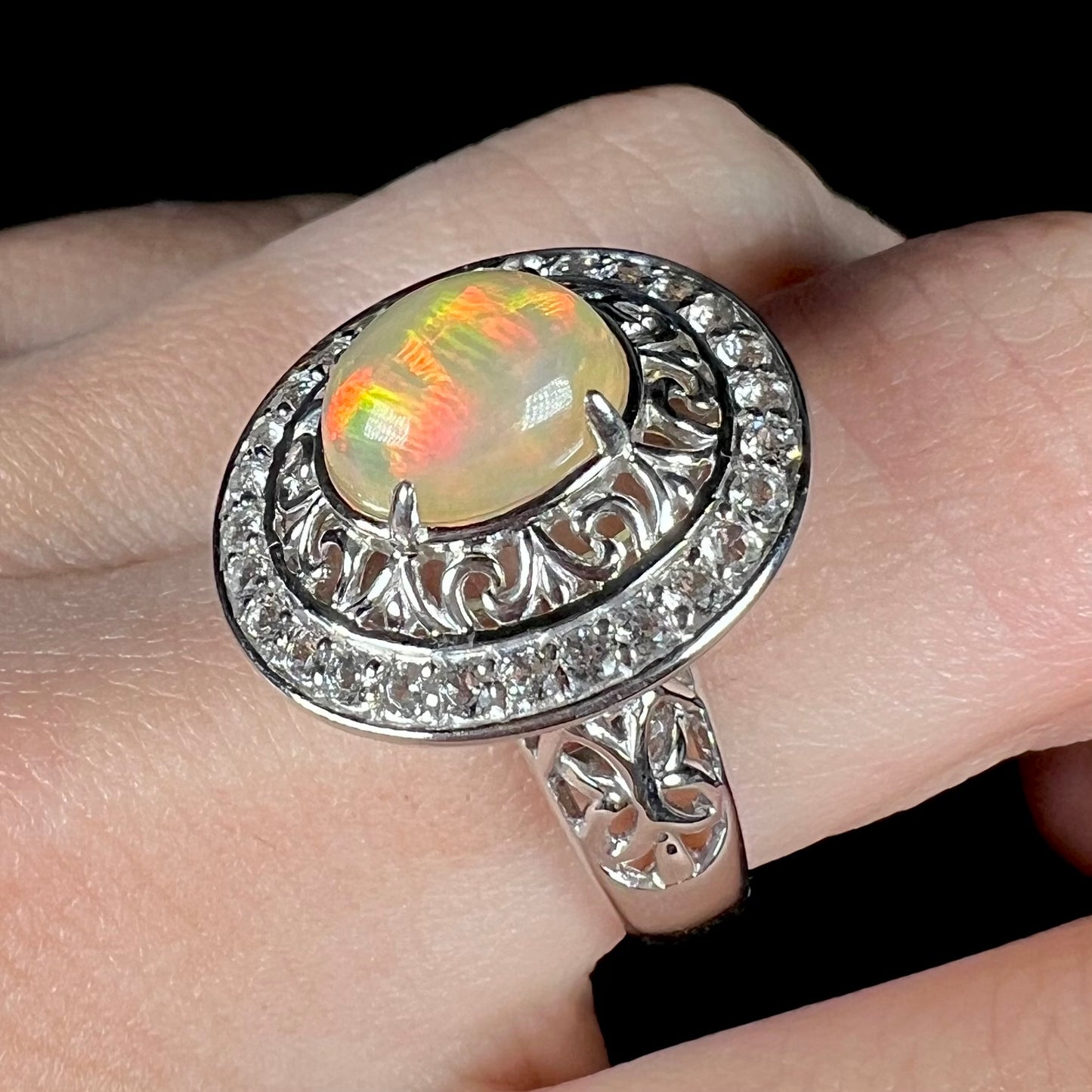 A sterling silver Ethiopian opal halo ring with a double halo of filigree and white topaz accents.