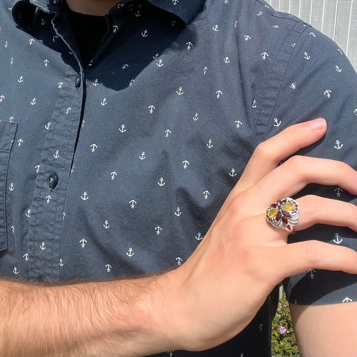 Silver Ethiopian opal and garnet statement ring, worn on a hand resting on the model's opposing shoulder.