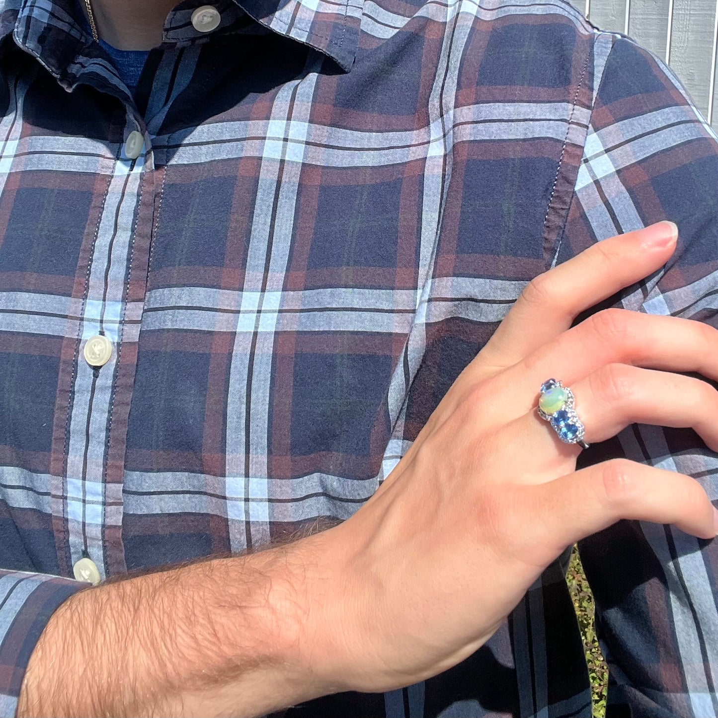 Sterling silver Ethiopian opal and kyanite ring worn on a hand, resting on the model's shoulder.