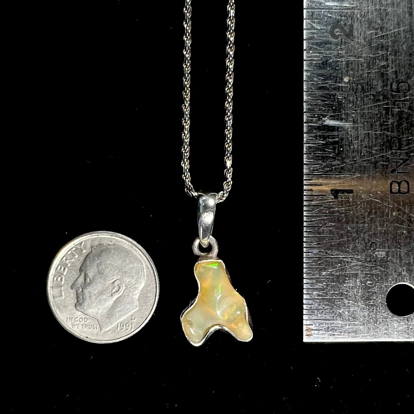 A freeform shaped Mexican fire opal necklace on a sterling silver rope chain.