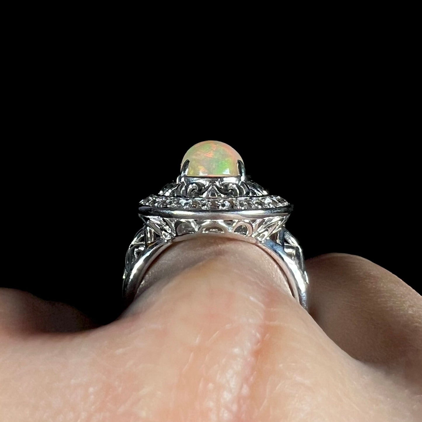 A sterling silver Ethiopian opal halo ring with a double halo of filigree and white topaz accents.