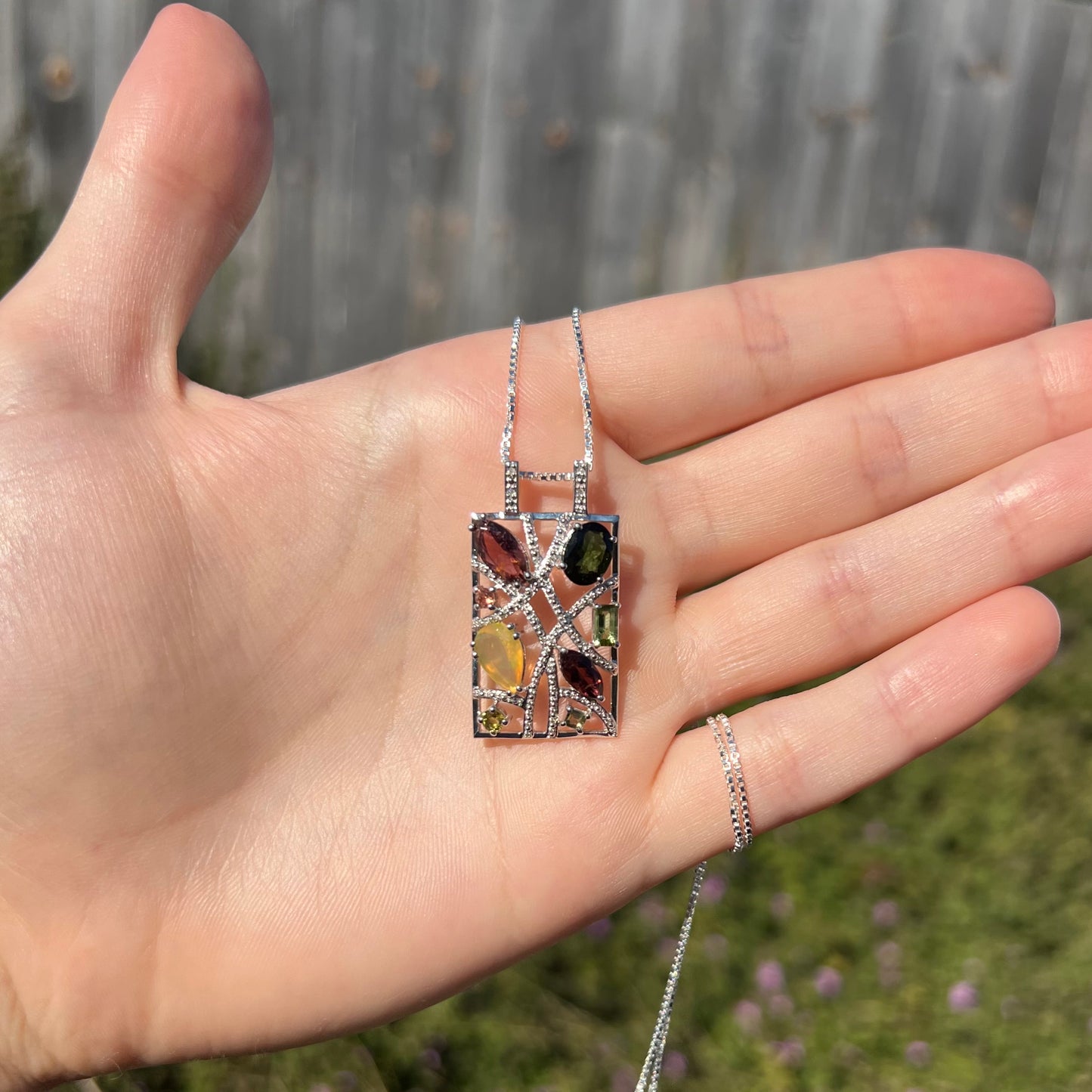 A sterling silver multi-gemstone necklace set with Ethiopian opal, tourmaline, and diamonds.