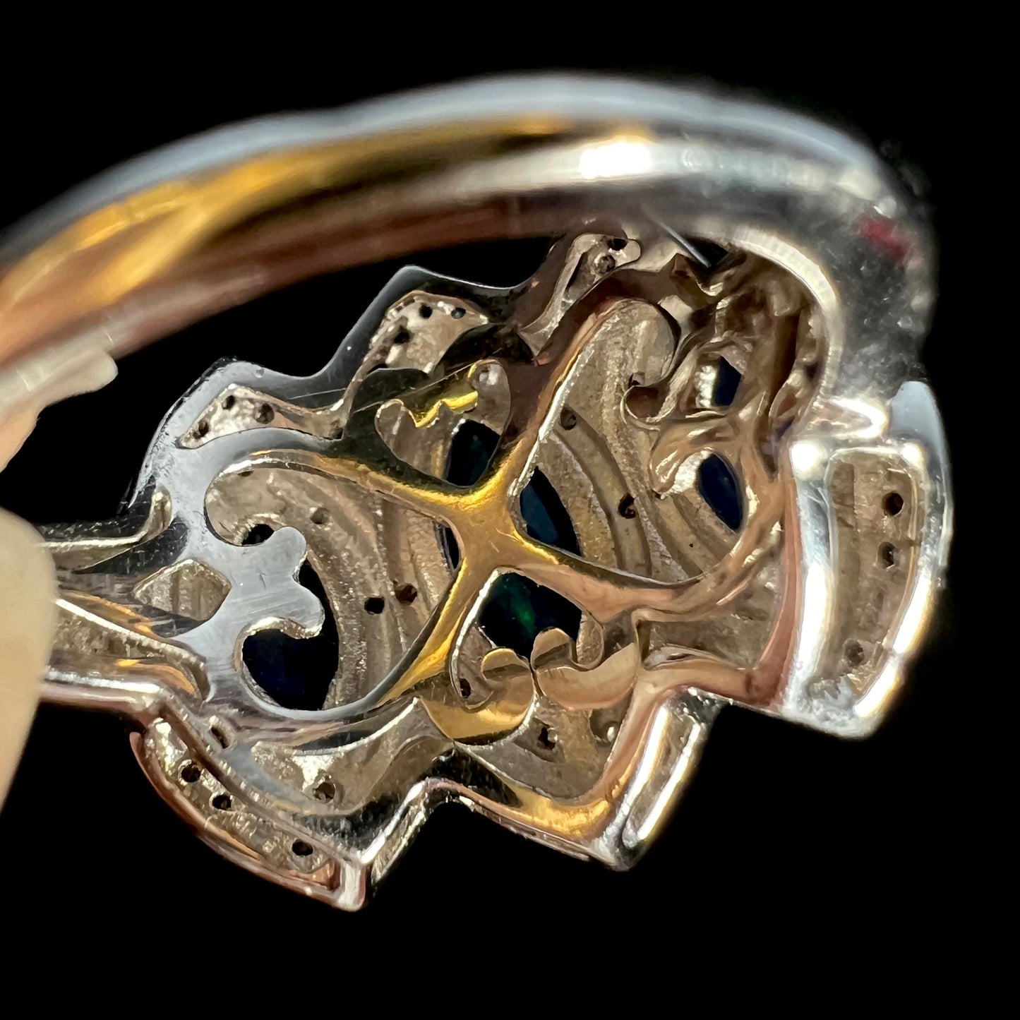 The undercarriage gallery of a silver opal ring showing filigree heart designs.
