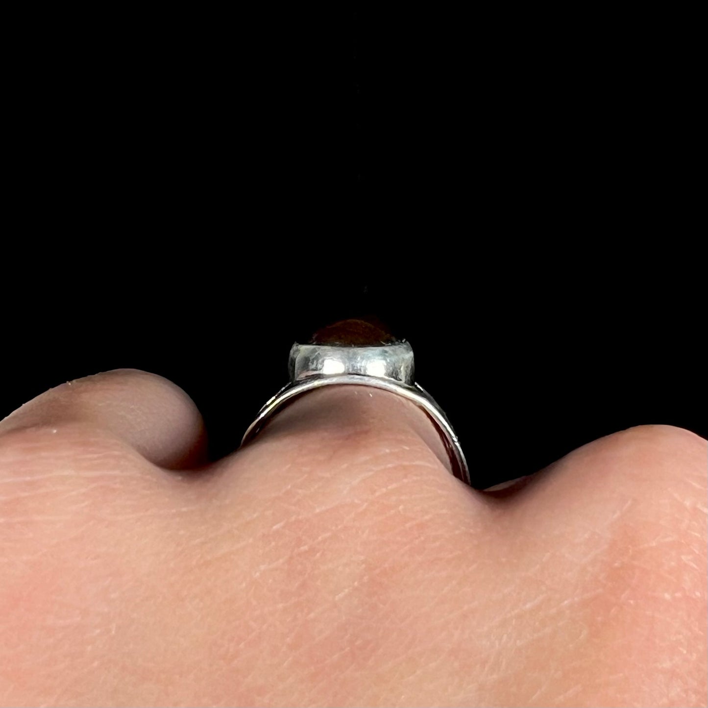 Side profile gallery view of a sterling silver ring, worn on a hand.
