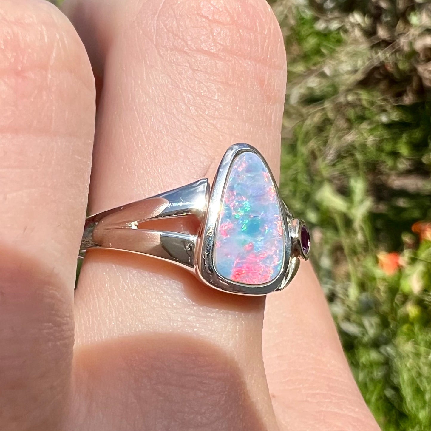 A two-tone sterling silver and yellow gold ring set with a black opal doublet and an amethyst accent.