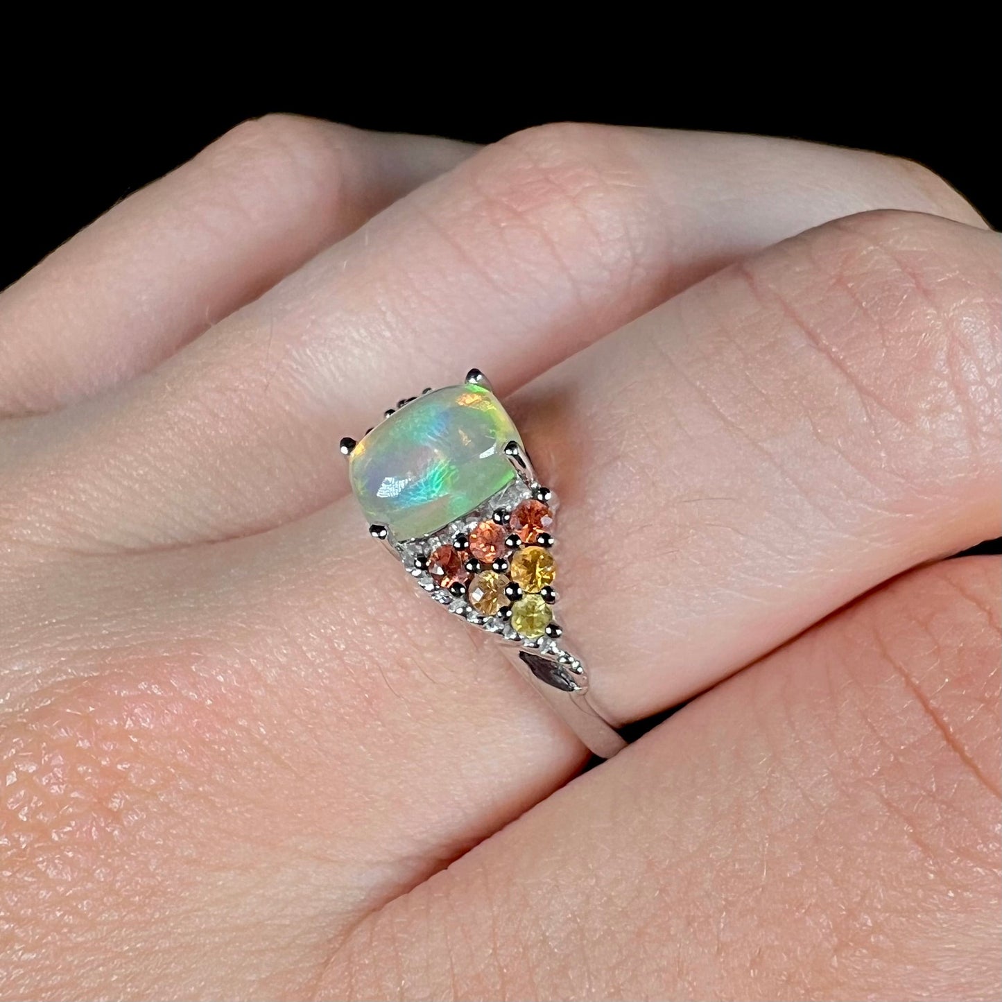 A ladies' silver ring set with a cushion cabochon cut Ethiopian fire opal stone and citrine accents.