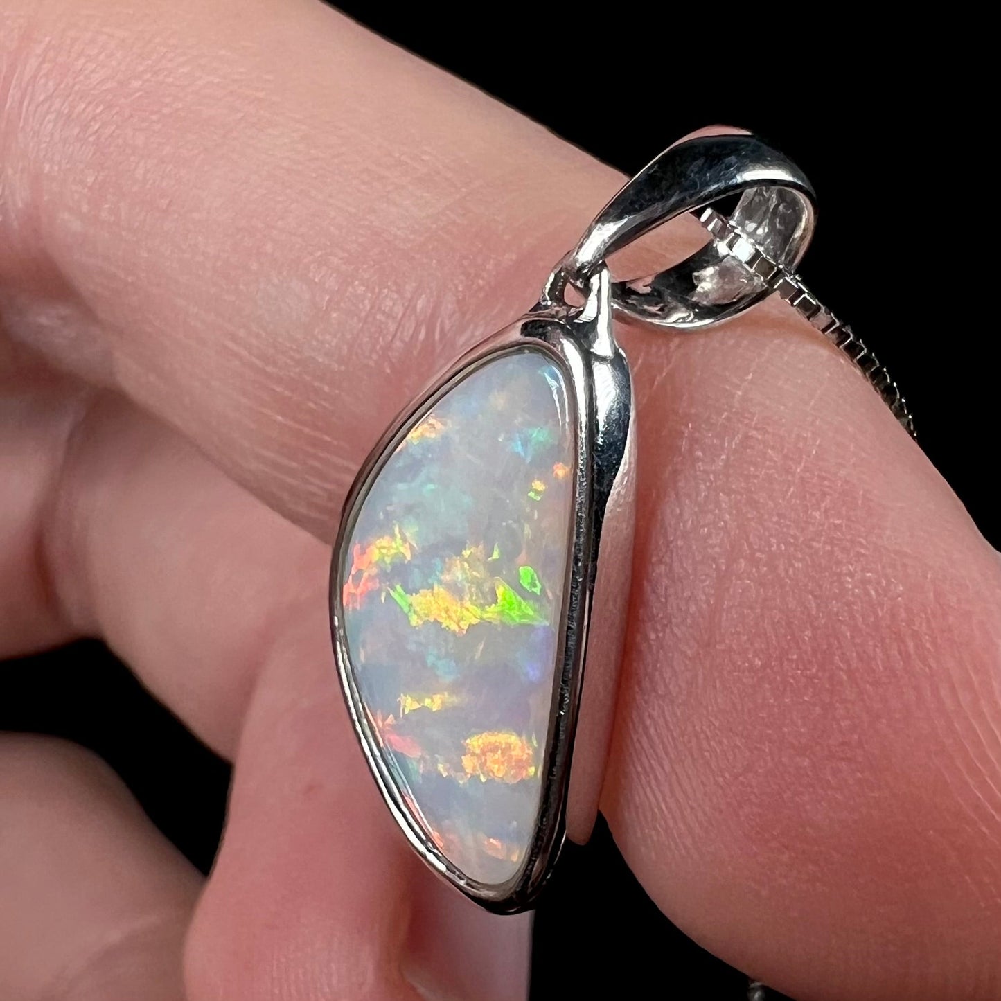 A sterling silver pendant bezel set with a white Australian crystal opal on a box chain.