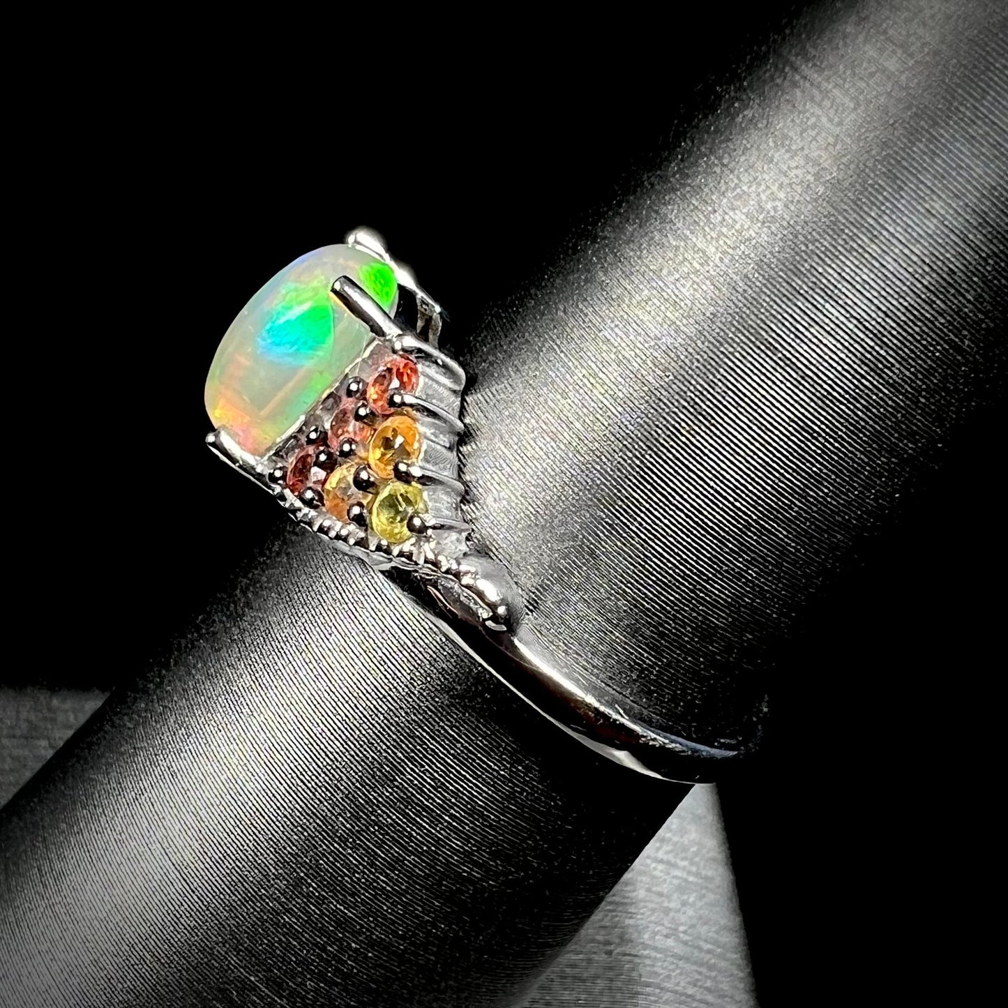 A ladies' silver ring set with a cushion cabochon cut Ethiopian fire opal stone and citrine accents.