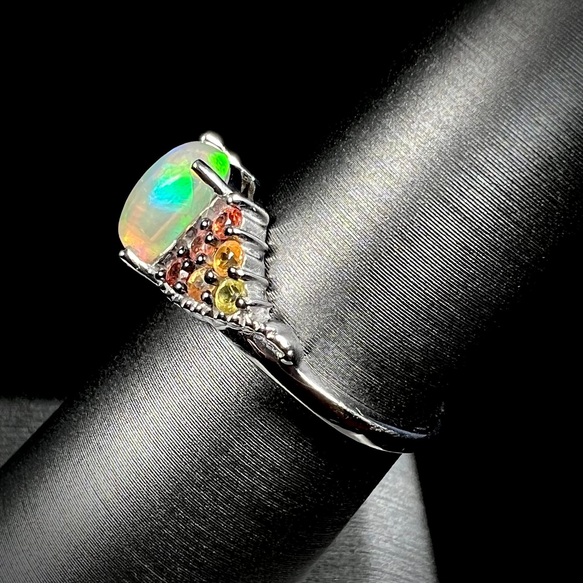 A ladies' silver ring set with a cushion cabochon cut Ethiopian fire opal stone and citrine accents.