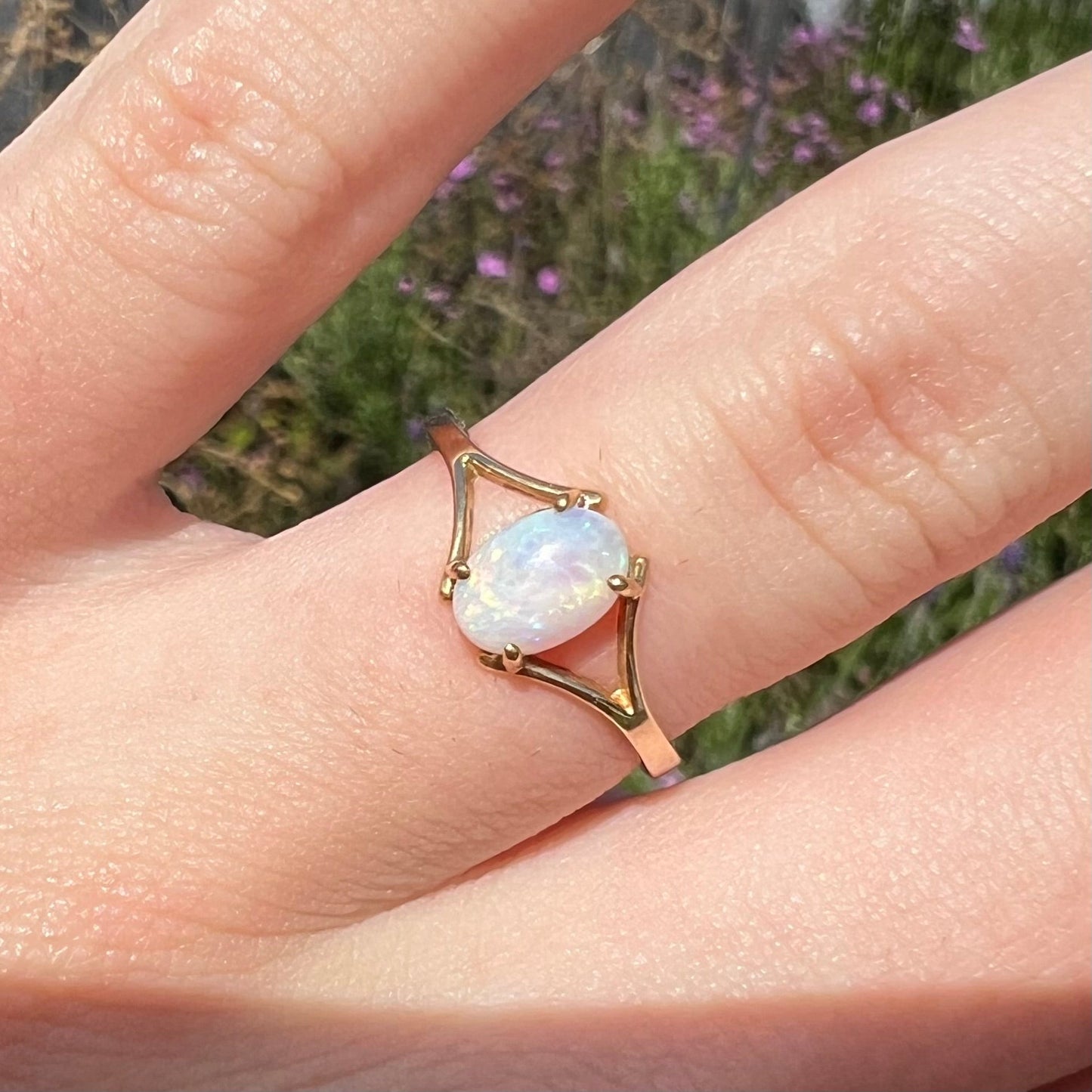 A ladies' simple opal solitaire ring. The ring is yellow gold with a split shank.