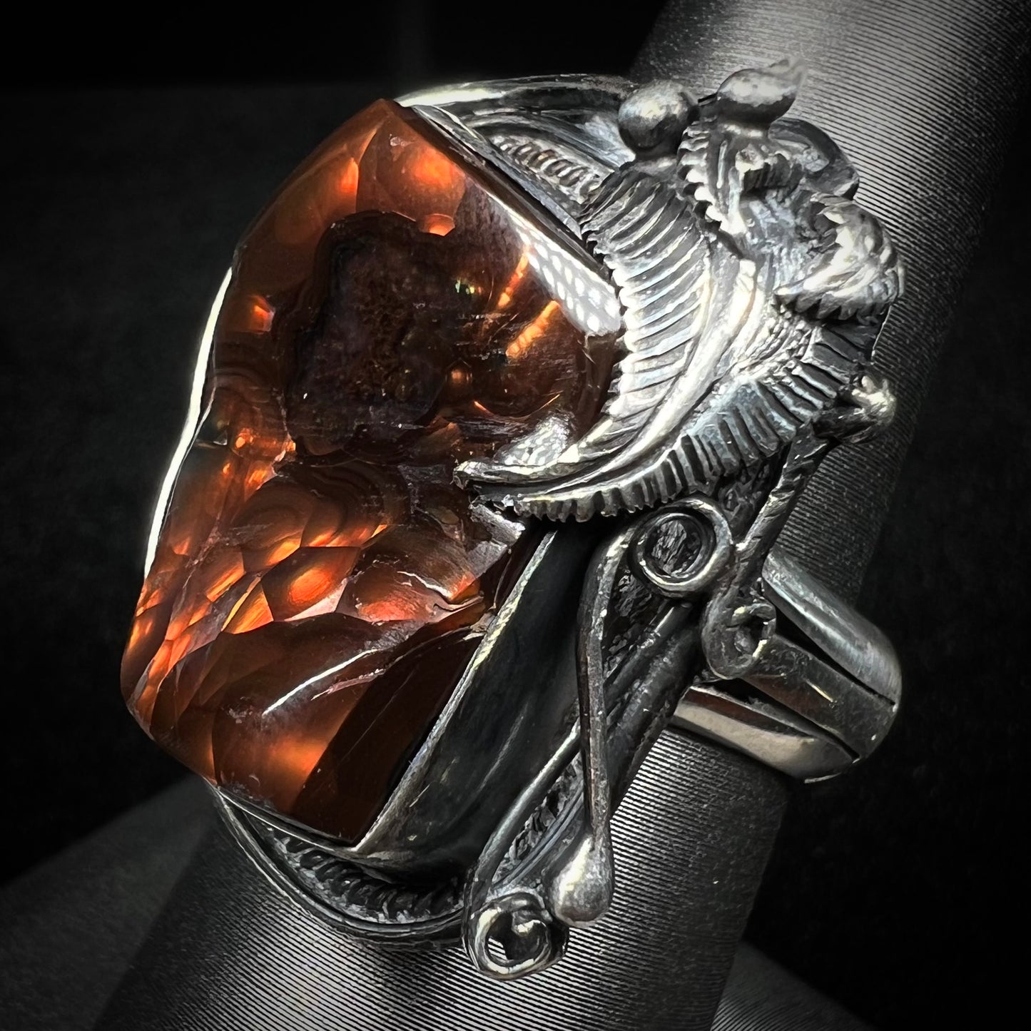 A men's silver, Southwest-style fire agate ring shown at an angled view.