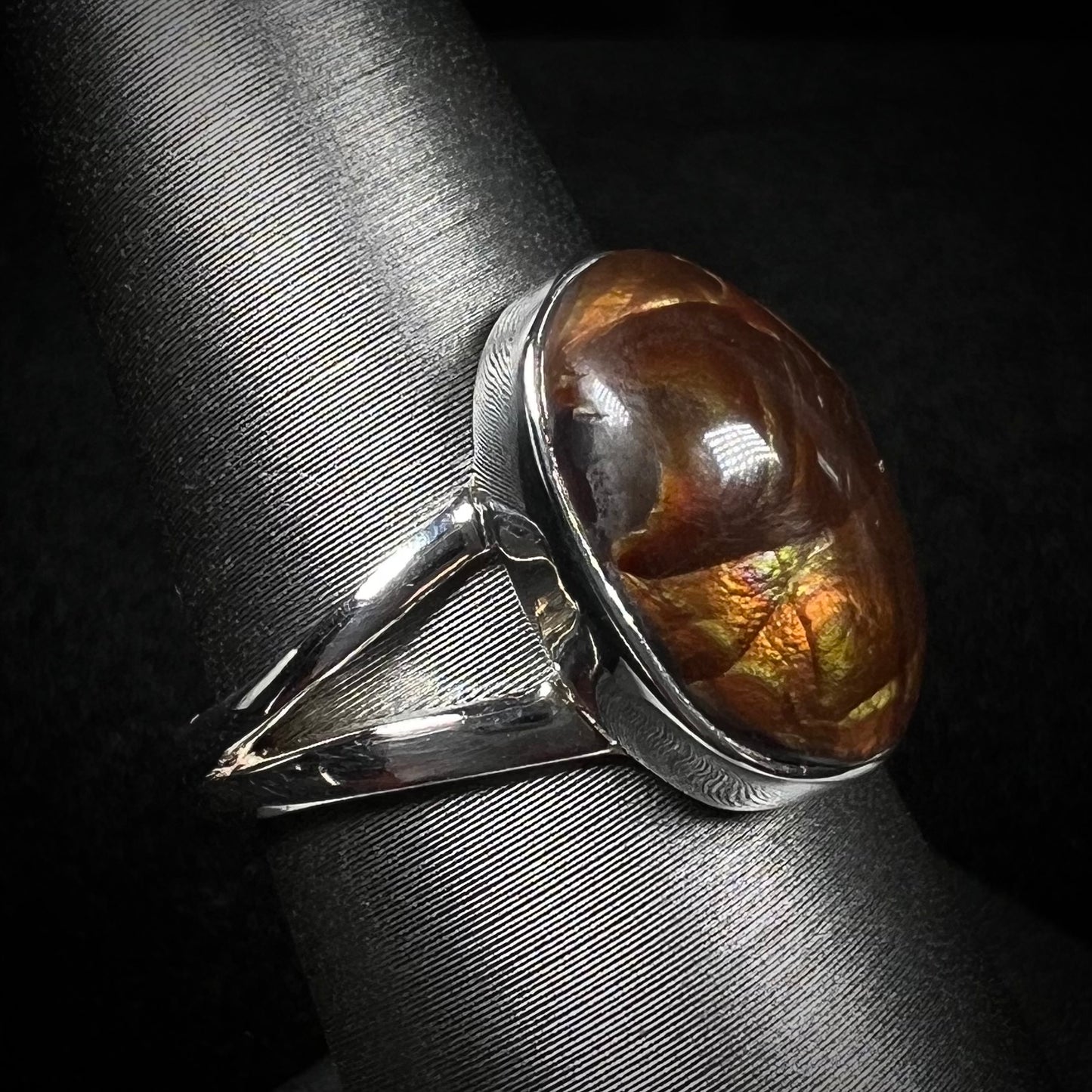 Angled view of a sterling silver Mexican fire agate ring with a split shank.