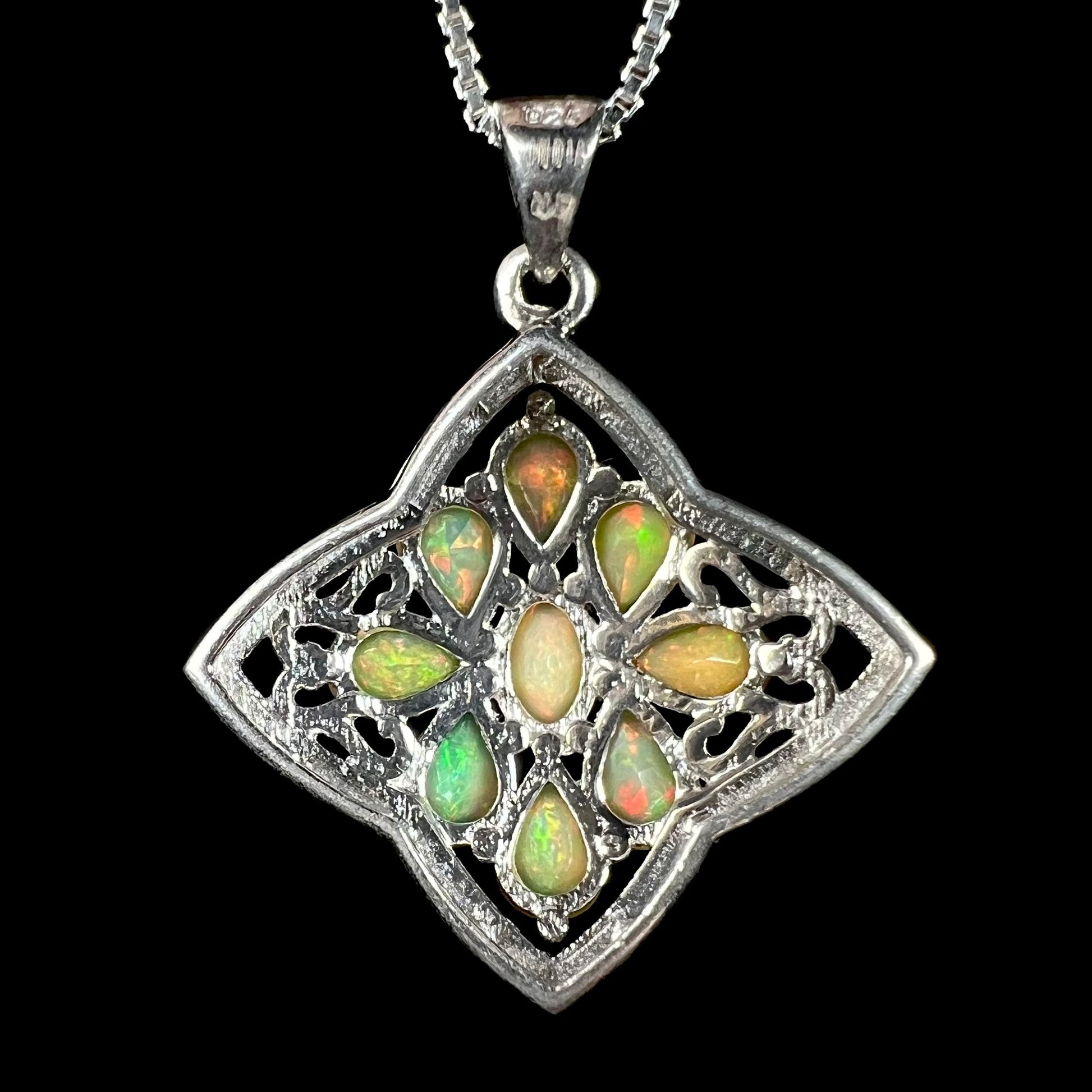Back side of a sterling silver Ethiopian opal pendant, shown on a box-style chain against a black backdrop.