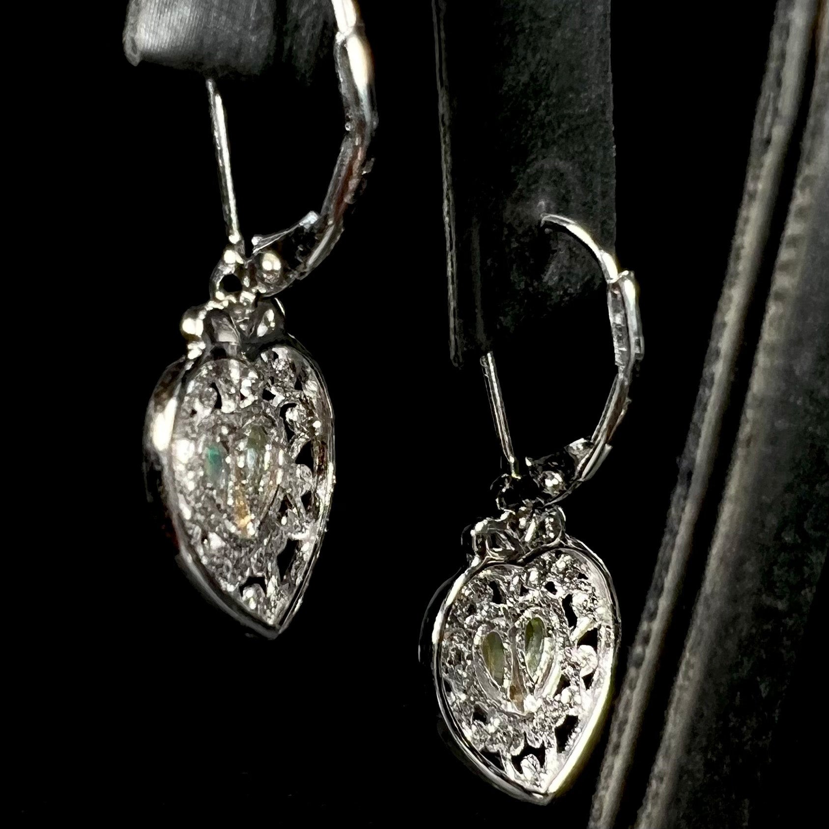 Back side of sterling silver filigree heart earrings set with opals.