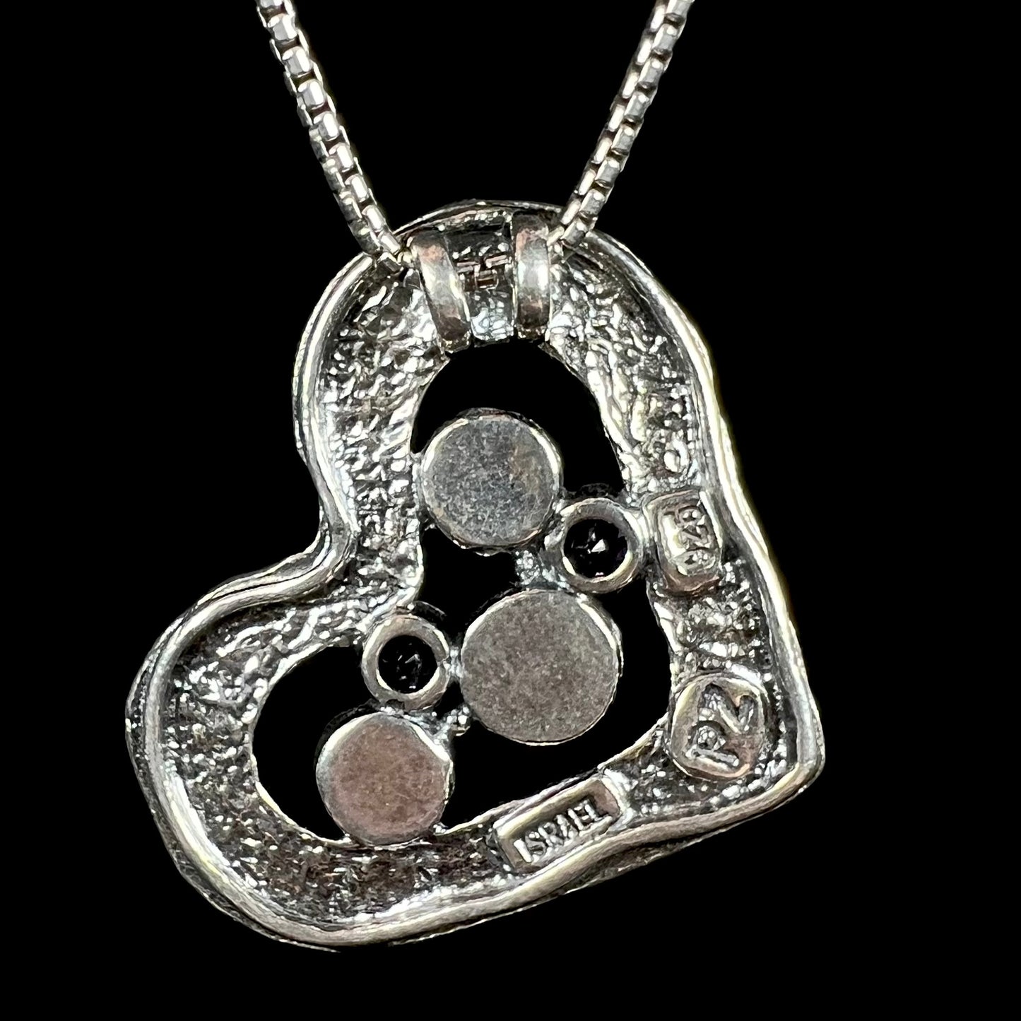 Back side of a multi-gemstone sterling silver heart necklace stamped "ISRAEL", "925", and "PZ".
