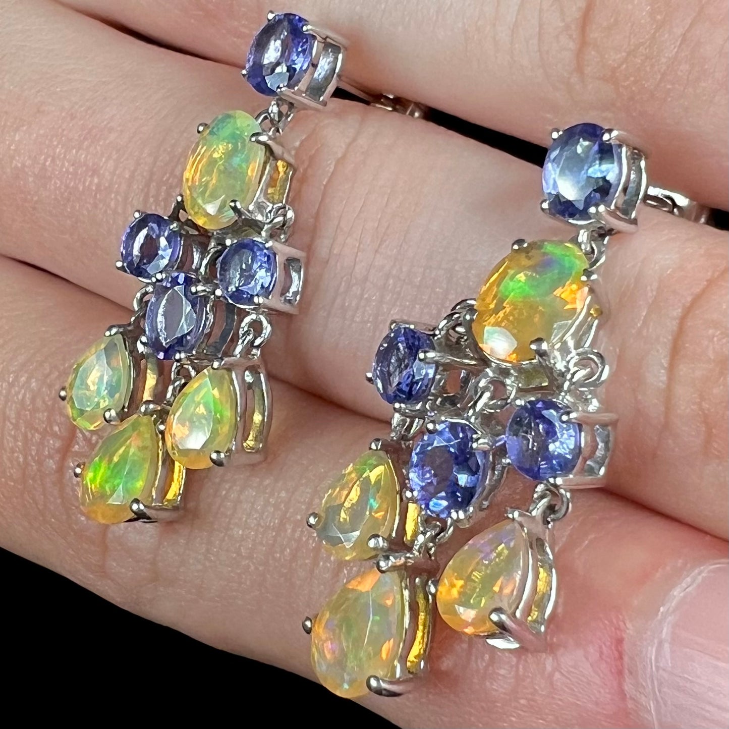 A pair of dangling sterling silver Ethiopian opal and tanzanite chandelier earrings.