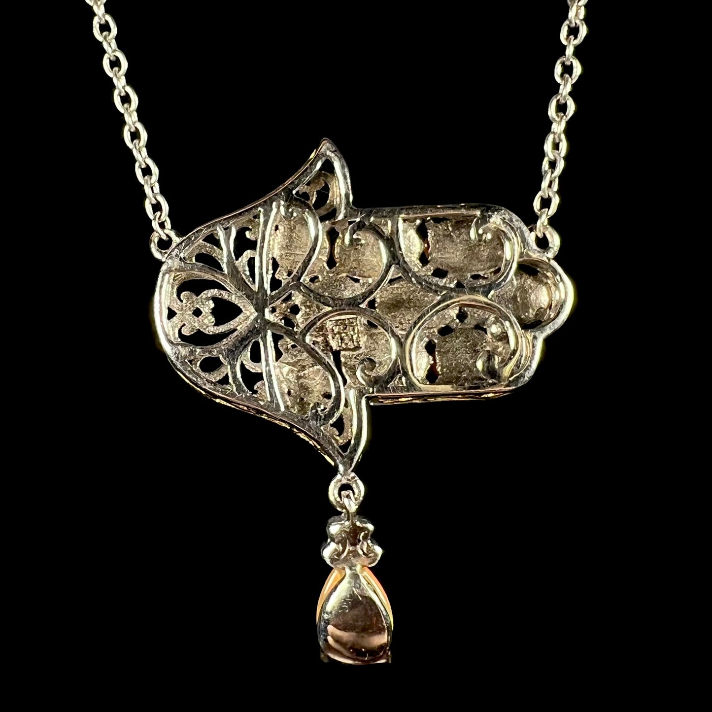 A sterling silver opal hamsa necklace, shown from the back. No opals are visible.