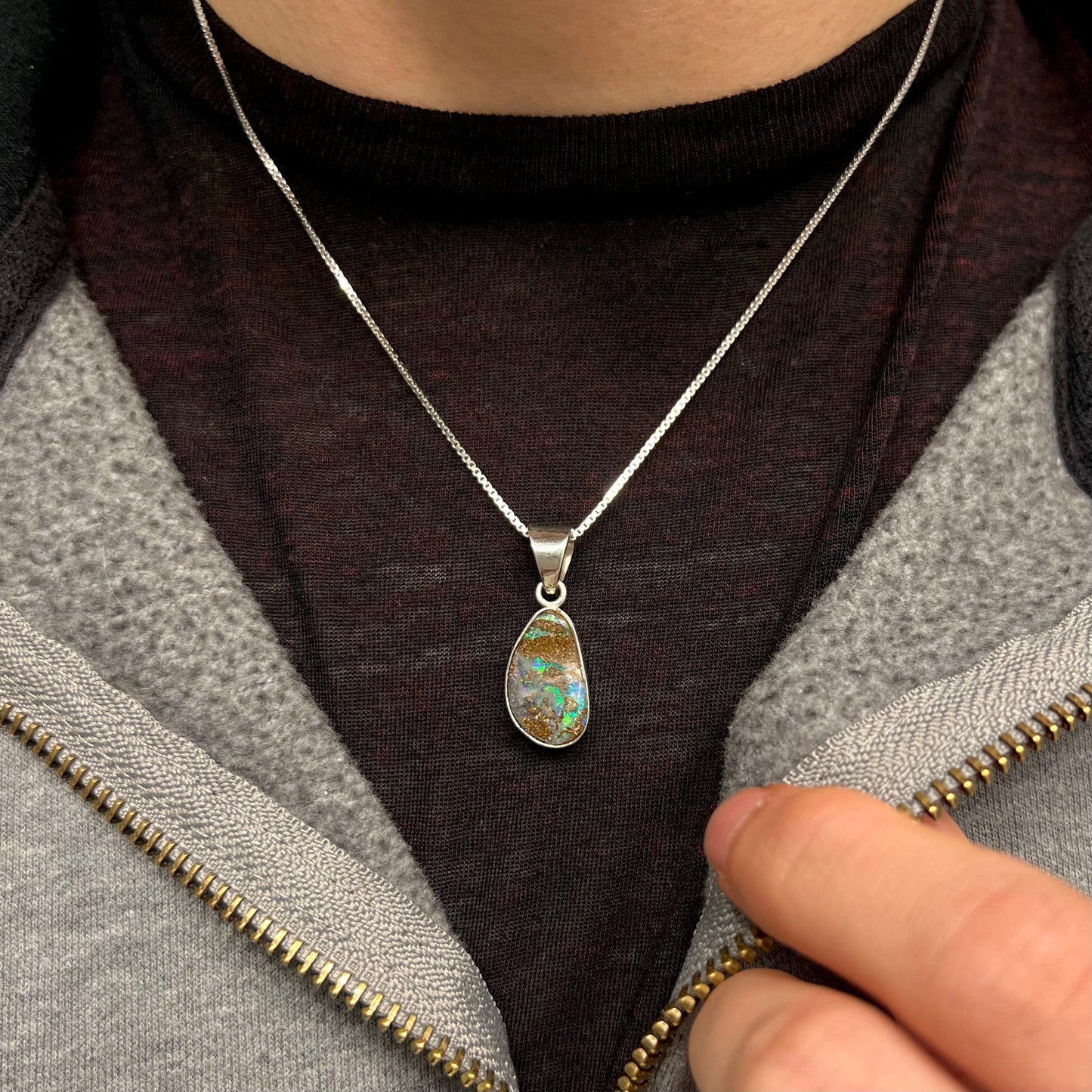 A sterling silver pendant set with an Australian boulder opal on a silver box chain.
