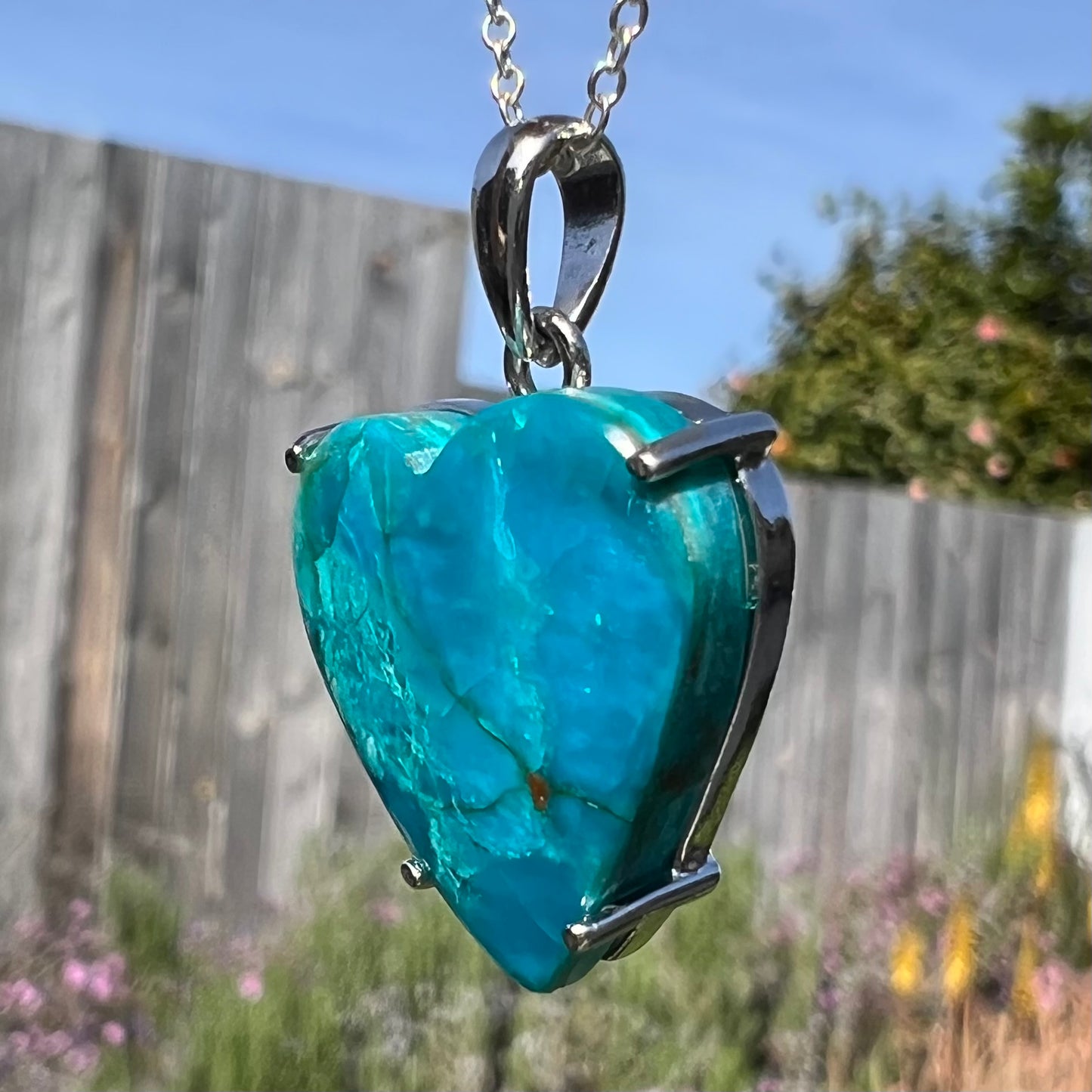 Opposite side of sunlit opal heart necklace, face fully lit with intense blue color.