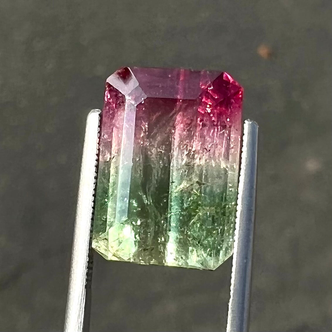 A loose pink and green emerald cut watermelon tourmaline gemstone.