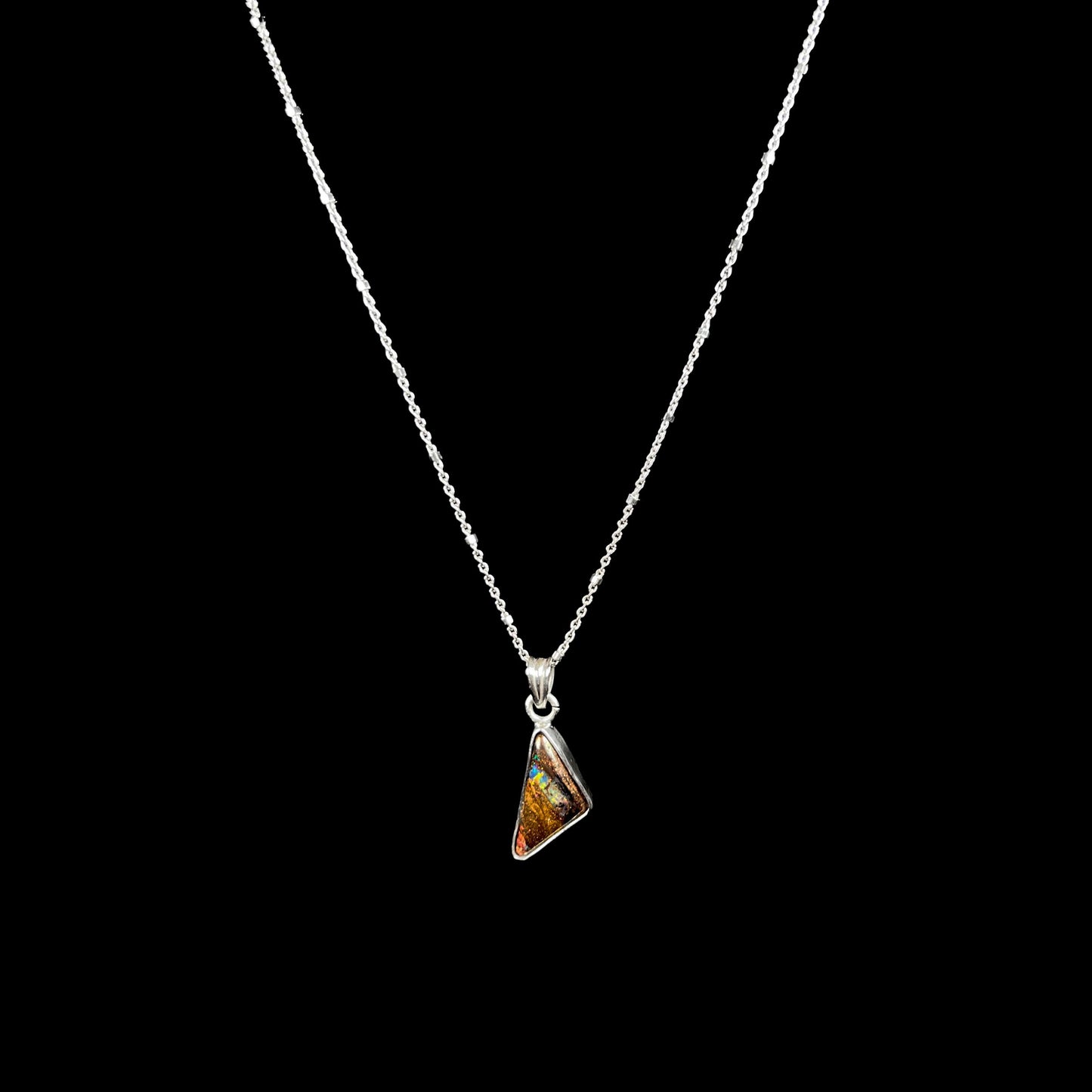 A triangle shaped opal necklace in sterling silver.  The opal shines with every color of the rainbow.