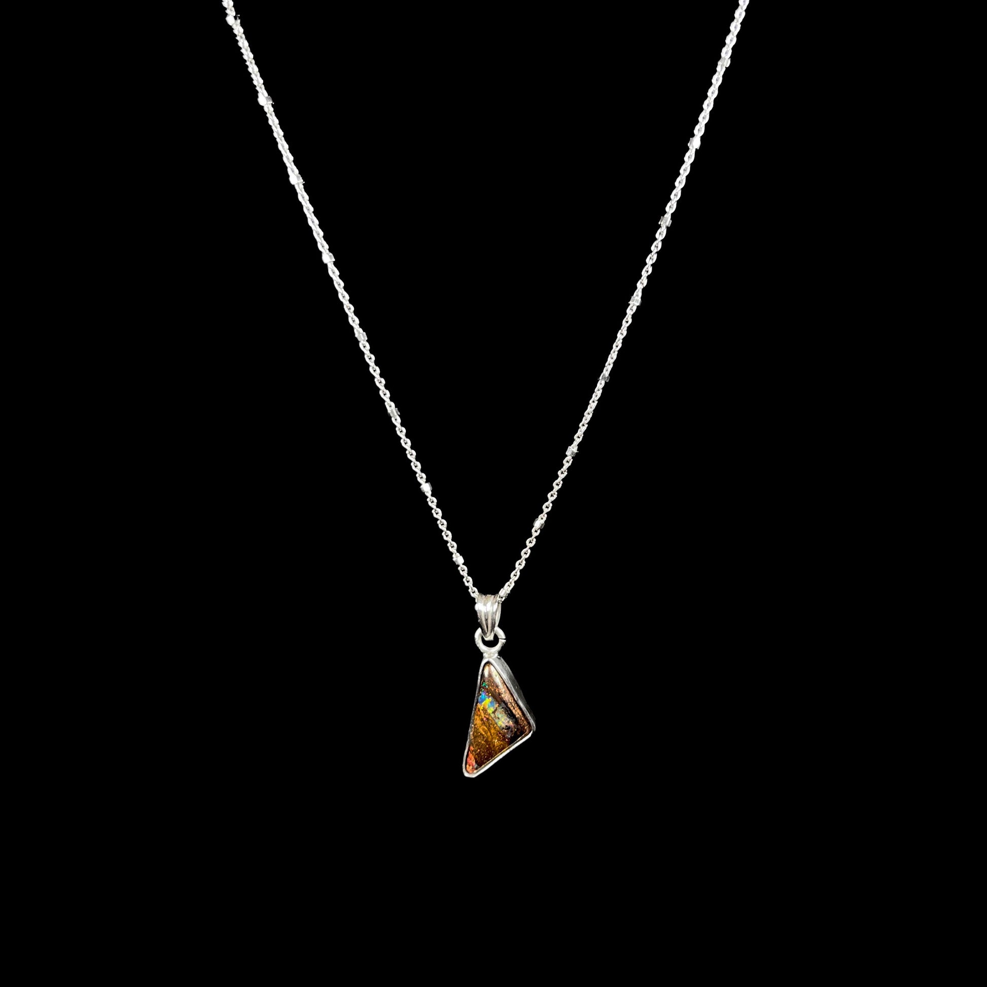 A triangle shaped opal necklace in sterling silver.  The opal shines with every color of the rainbow.