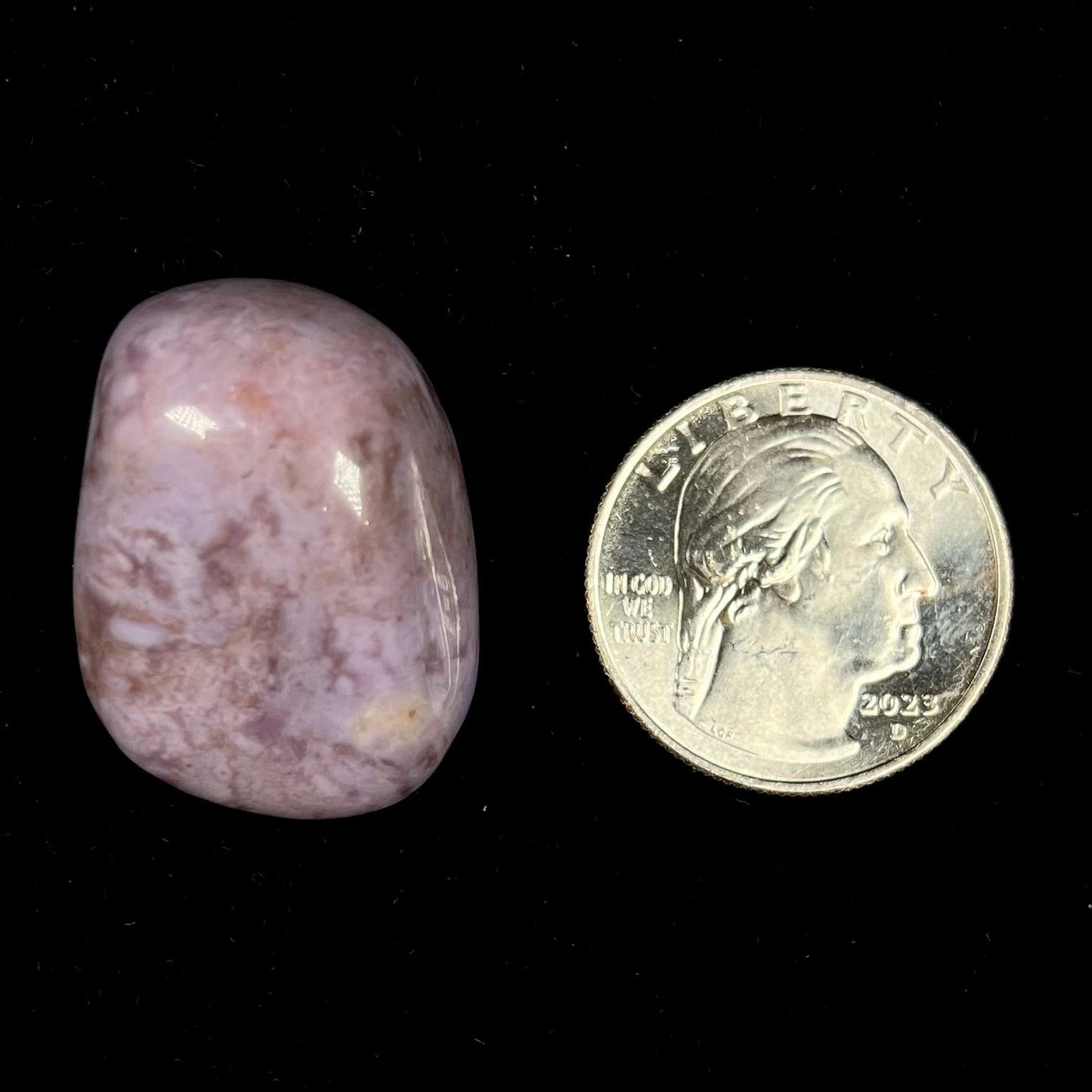 A tumbled Turkish purple jade stone. The material is a "white" lilac purple color.