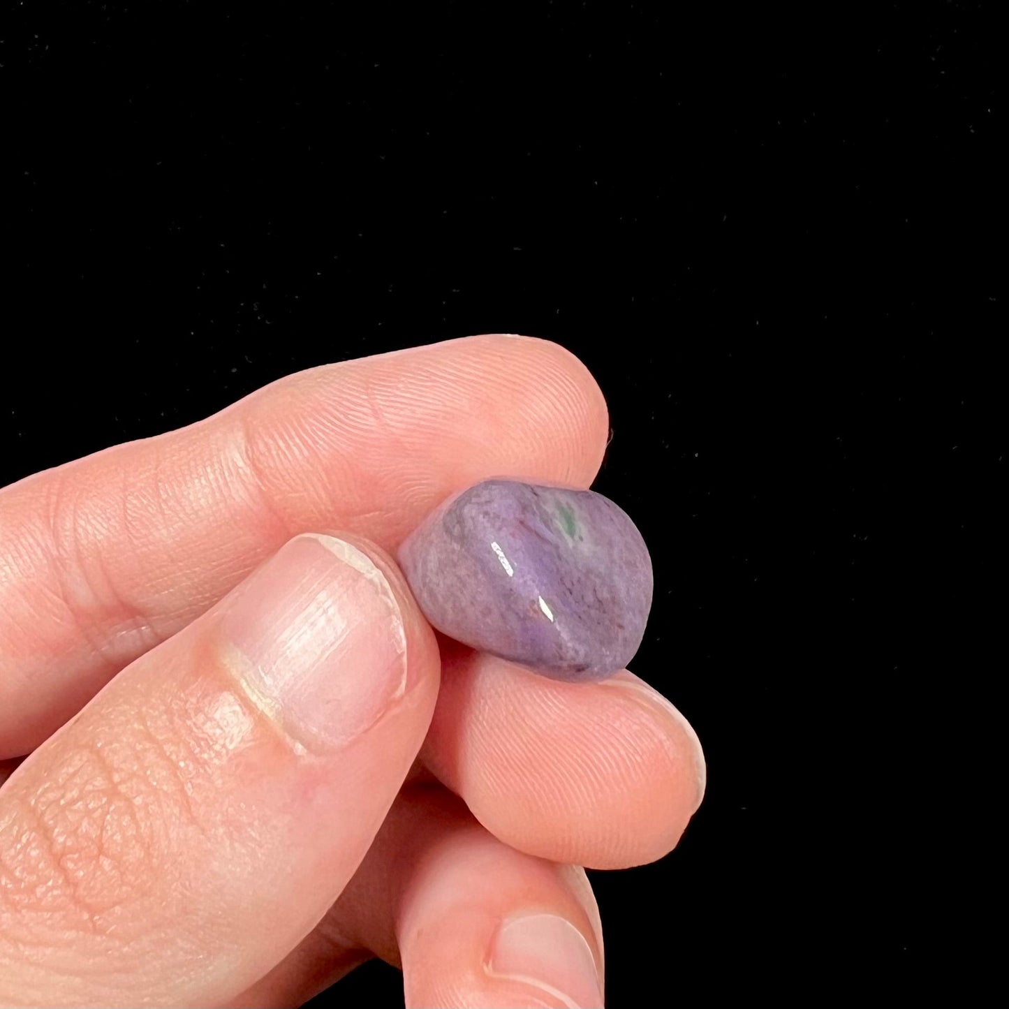 A tumbled purple turkiyenite jade stone from Borsa, Turkey. The stone has a green jadeite inclusion.