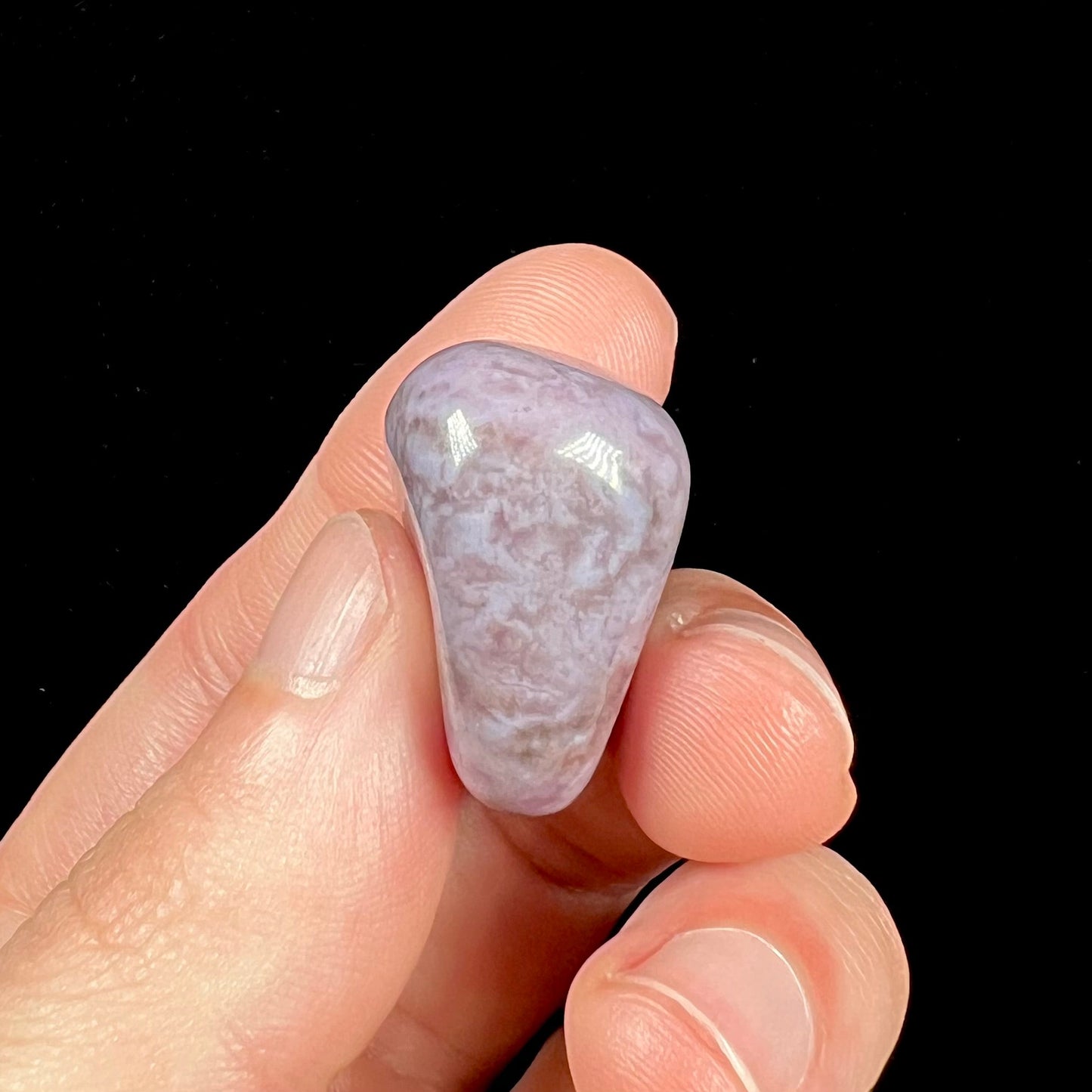 A tumbled Turkish purple jade stone. The material is a "white" lilac purple color.