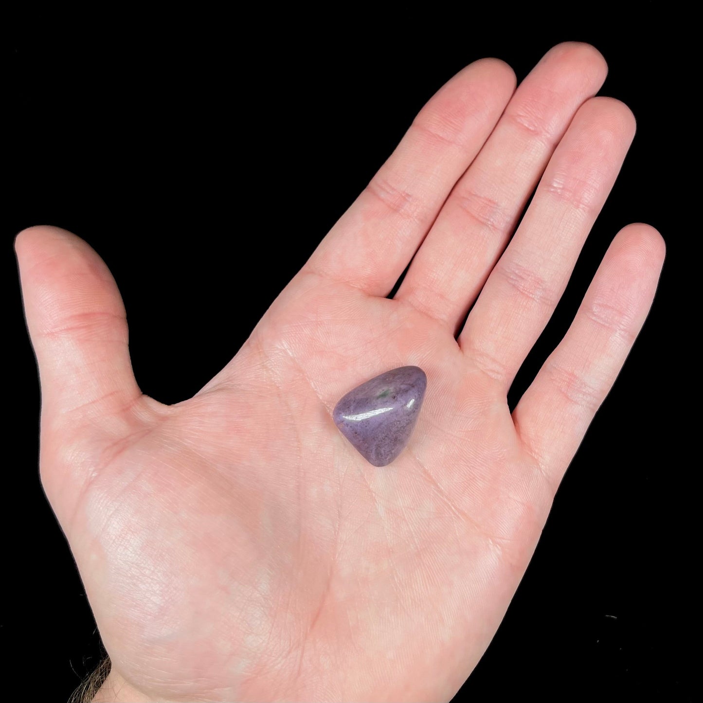 A tumbled purple turkiyenite jade stone from Borsa, Turkey. The stone has a green jadeite inclusion.